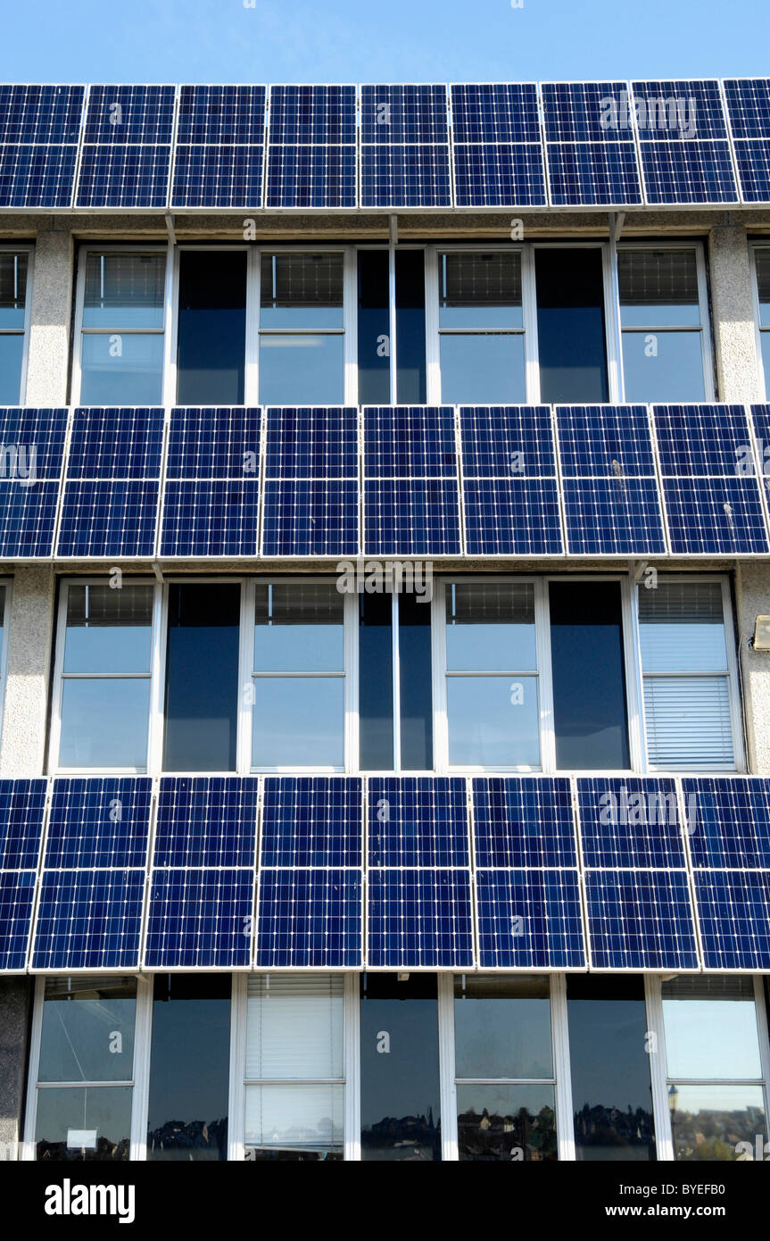 Rows of photovoltaic solar panels on the side of a council building in
