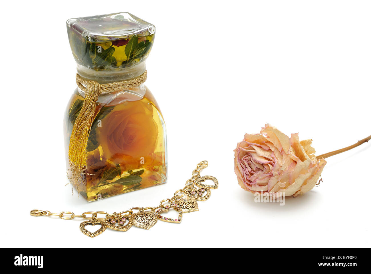 Bath oils, dried rose, and heart shaped bracelet isolated on white