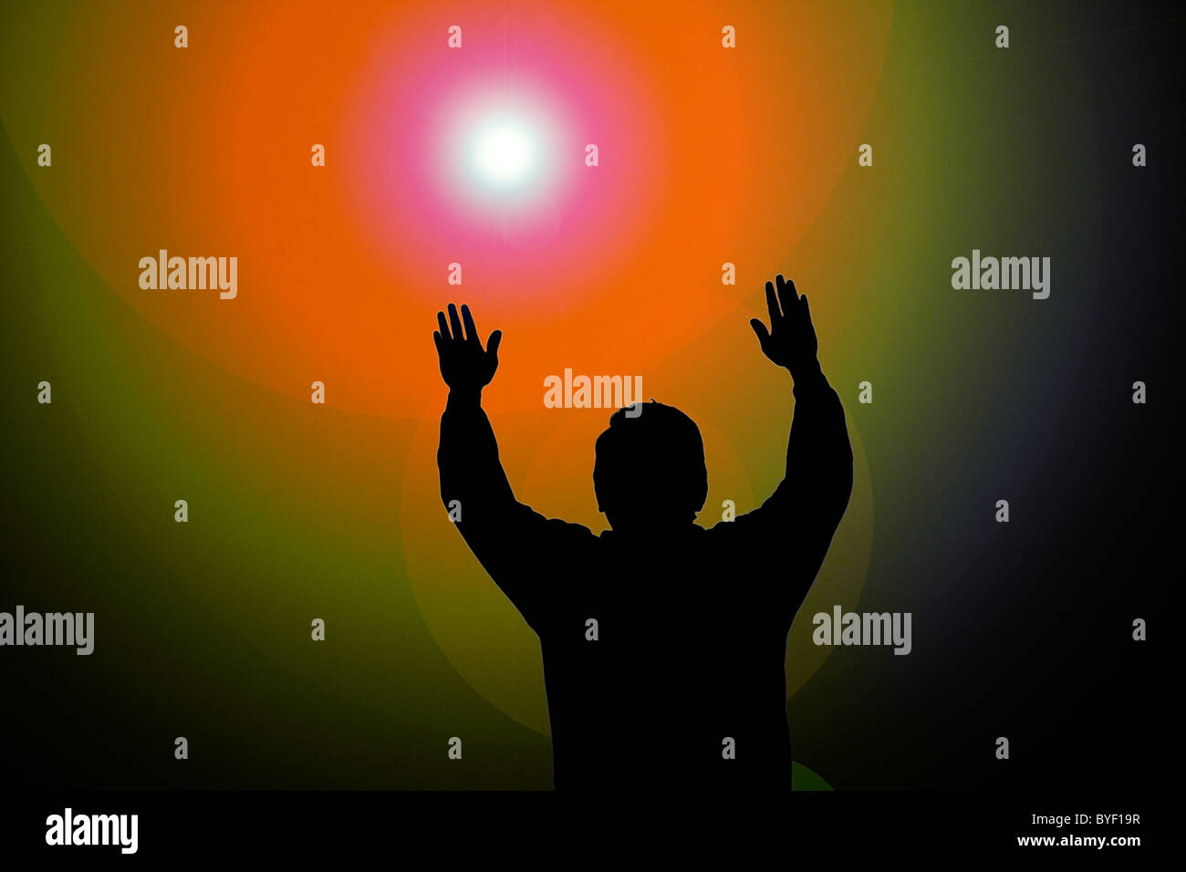 Colorful sun beam on man with hands up Stock Photo