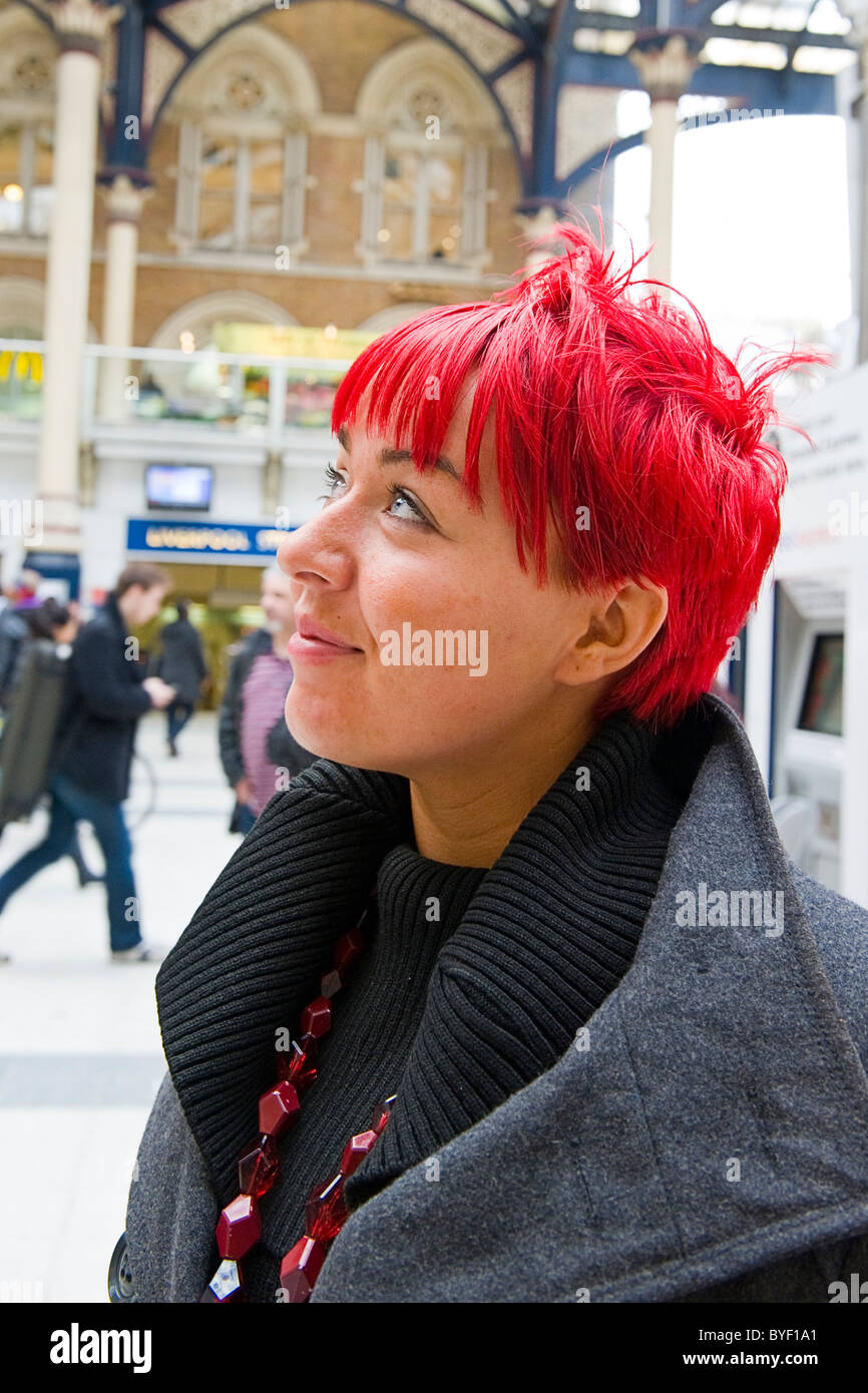 London , Liverpool Street Station , pretty young girl passenger with bright  red hair & red beads looking up at departure board Stock Photo - Alamy