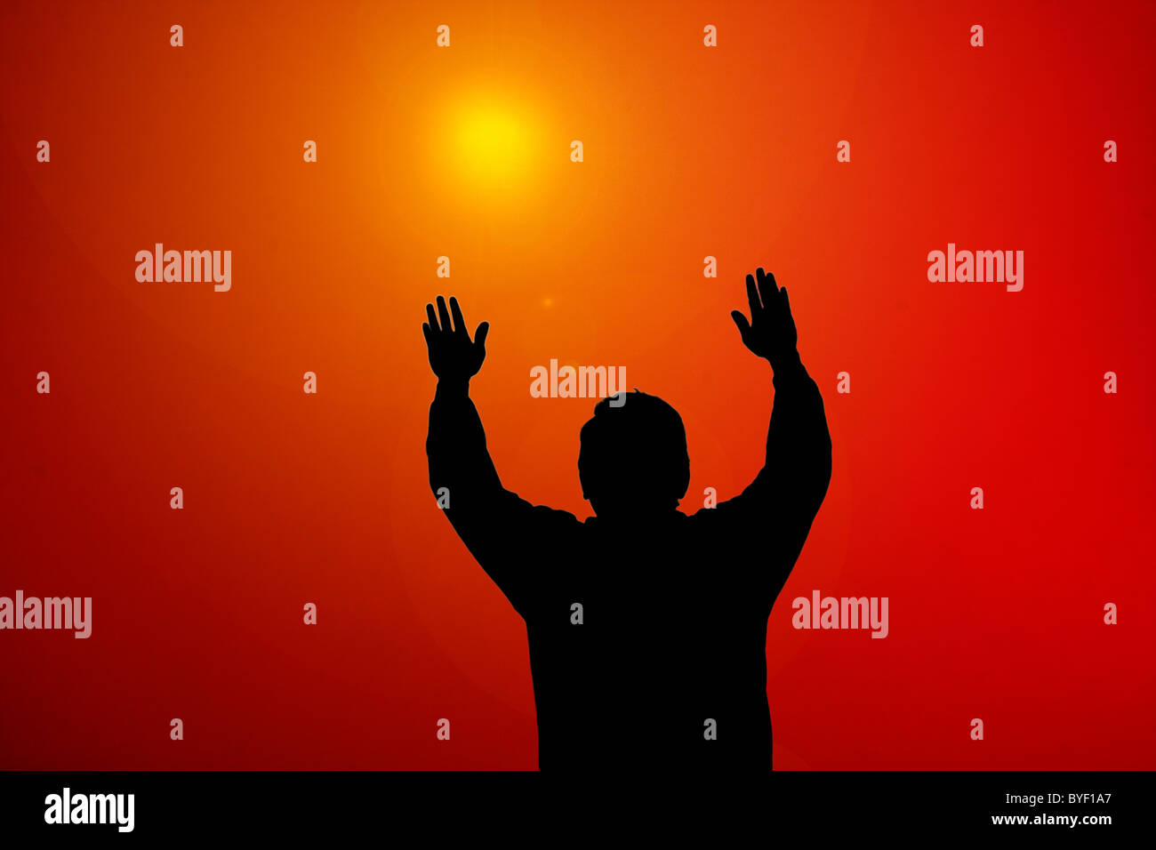 Sunset light beam shining on man with hands up Stock Photo