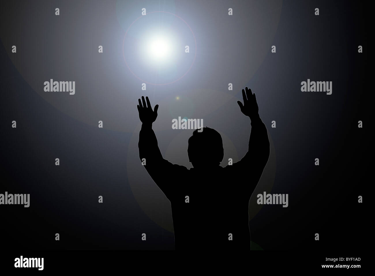 Sun beam shining on man with hands up Stock Photo