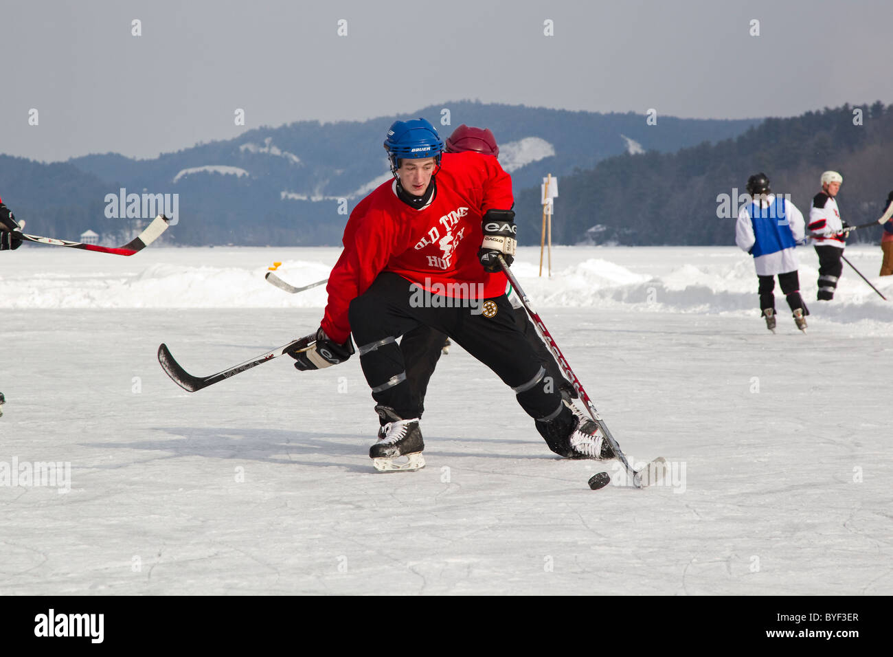 Hockey players play ice hockey in pond hockey tournament, on frozen lake in Fairlee, Vermont, New England, USA, sport Stock Photo