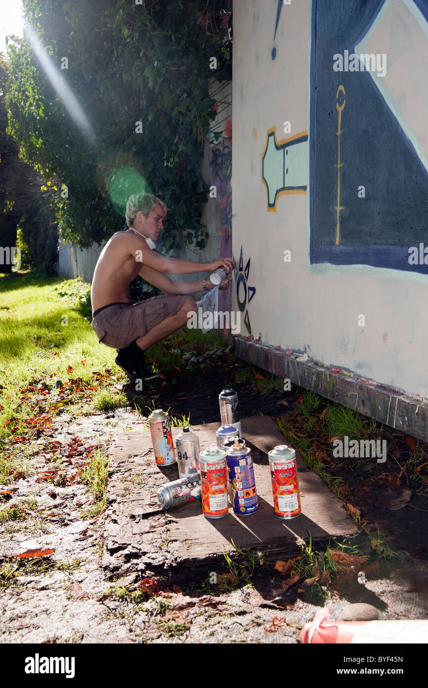 a young boy artist, who makes graffiti into art on public buildings Stock Photo