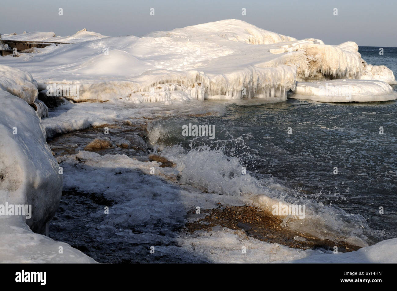 Ice and snow cover the shore and docks on Lake Michigan after a winter blizzard. Stock Photo