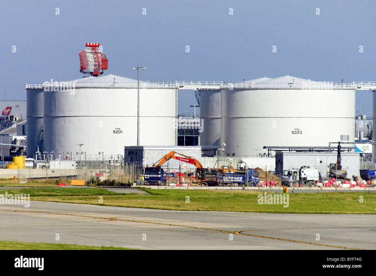 Aviation fuel tanks at London Heathrow Airport. Airport radar visible in background. Stock Photo