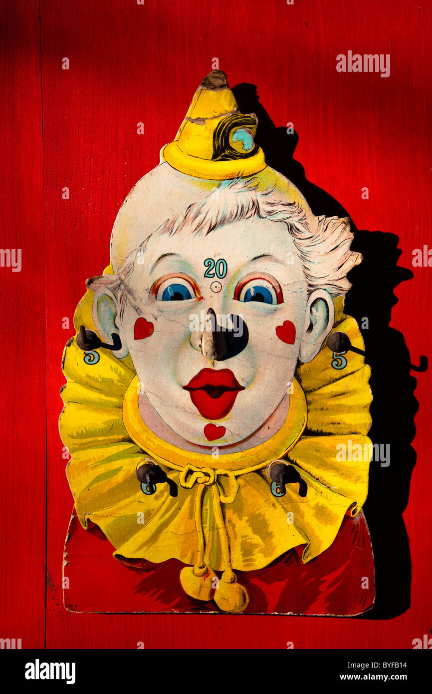 Old clown toy on red wall Stock Photo