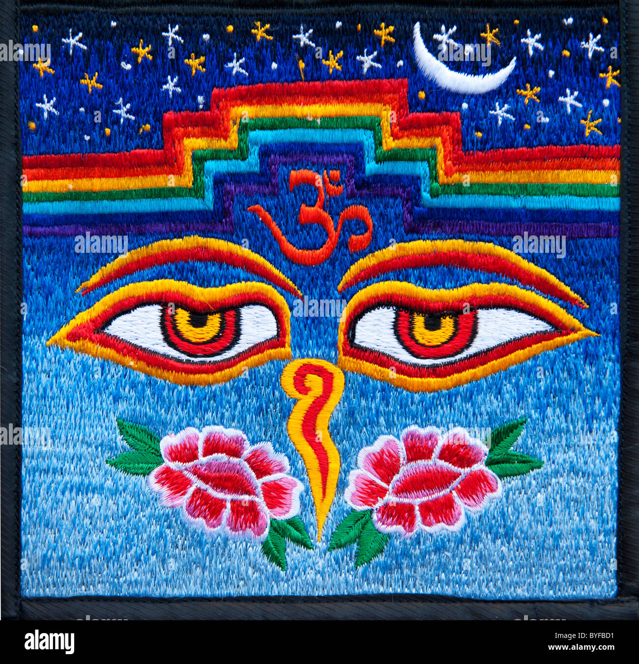 Multicoloured Hindu OM / AUM and Tibetan Buddhist eyes embroidery pattern. Indian handicraft. India Stock Photo