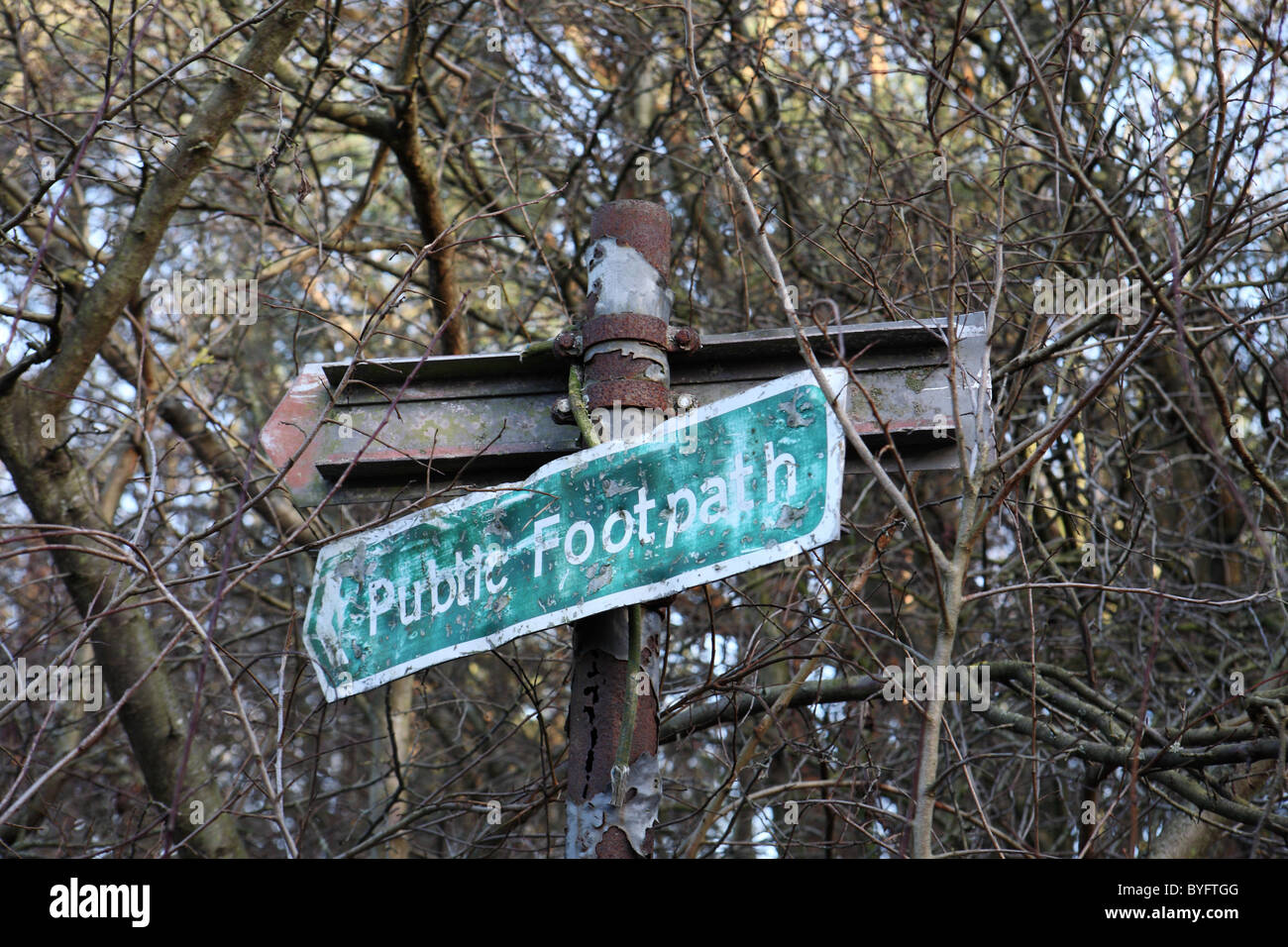 An overgrown and rusting semi derelict public footpath sign, Washington, North East England, UK Stock Photo