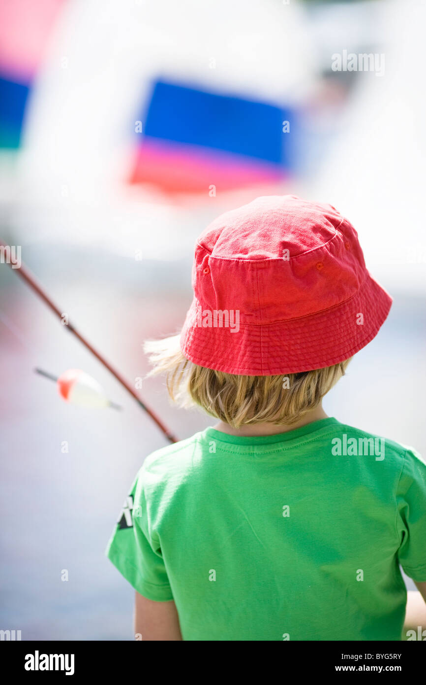 Boy holding fishing rod, rear view Stock Photo