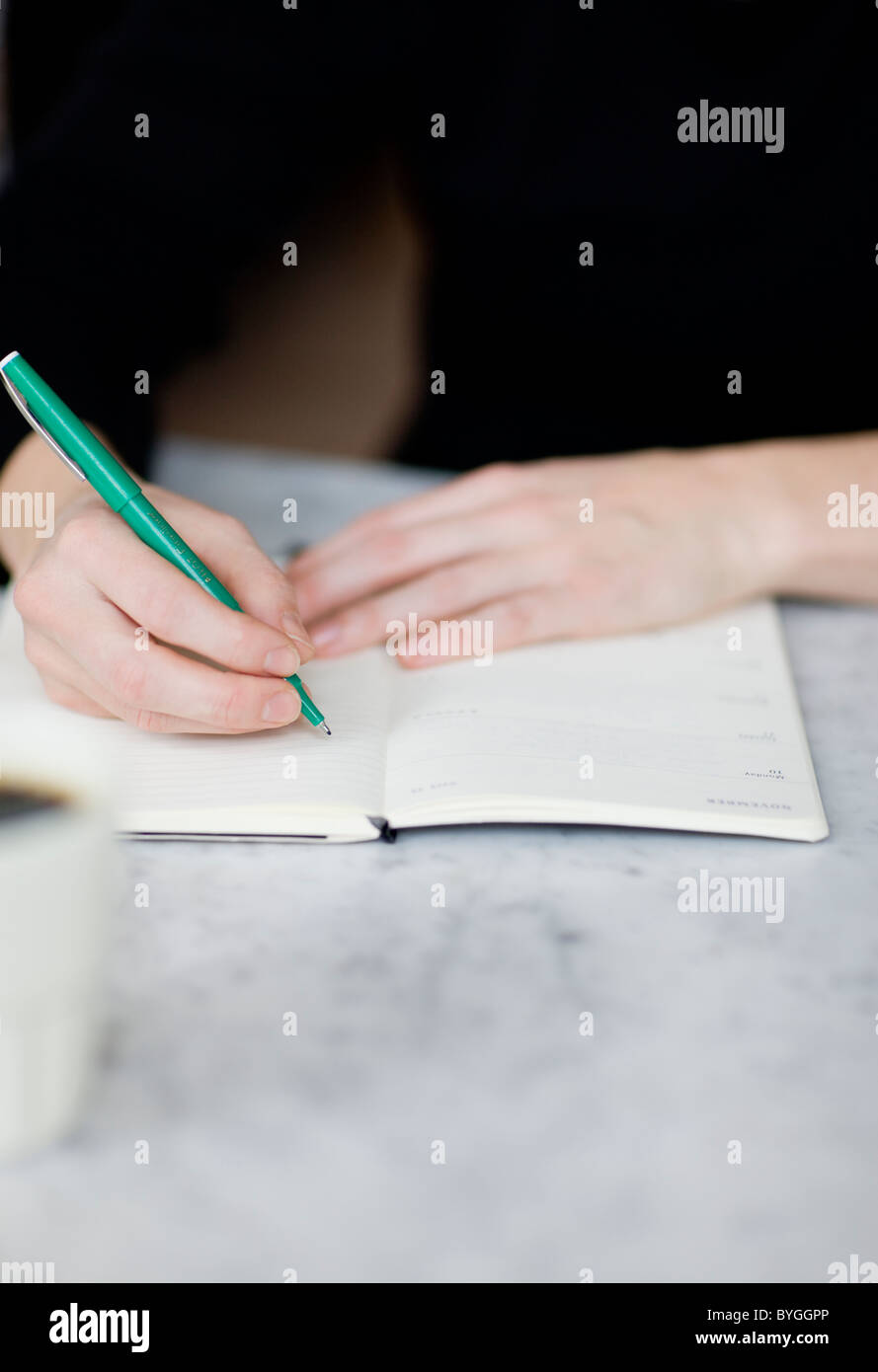 Woman writing on diary Stock Photo