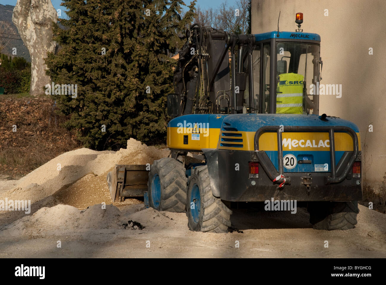 A headless digger driver lifting a bucket full of sand Stock Photo Alamy