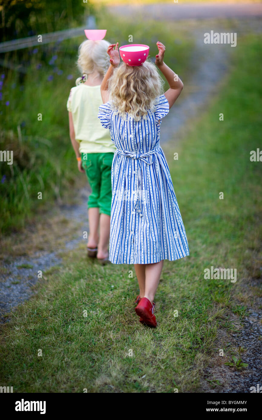 Girls carrying bowls on heads Stock Photo Alamy