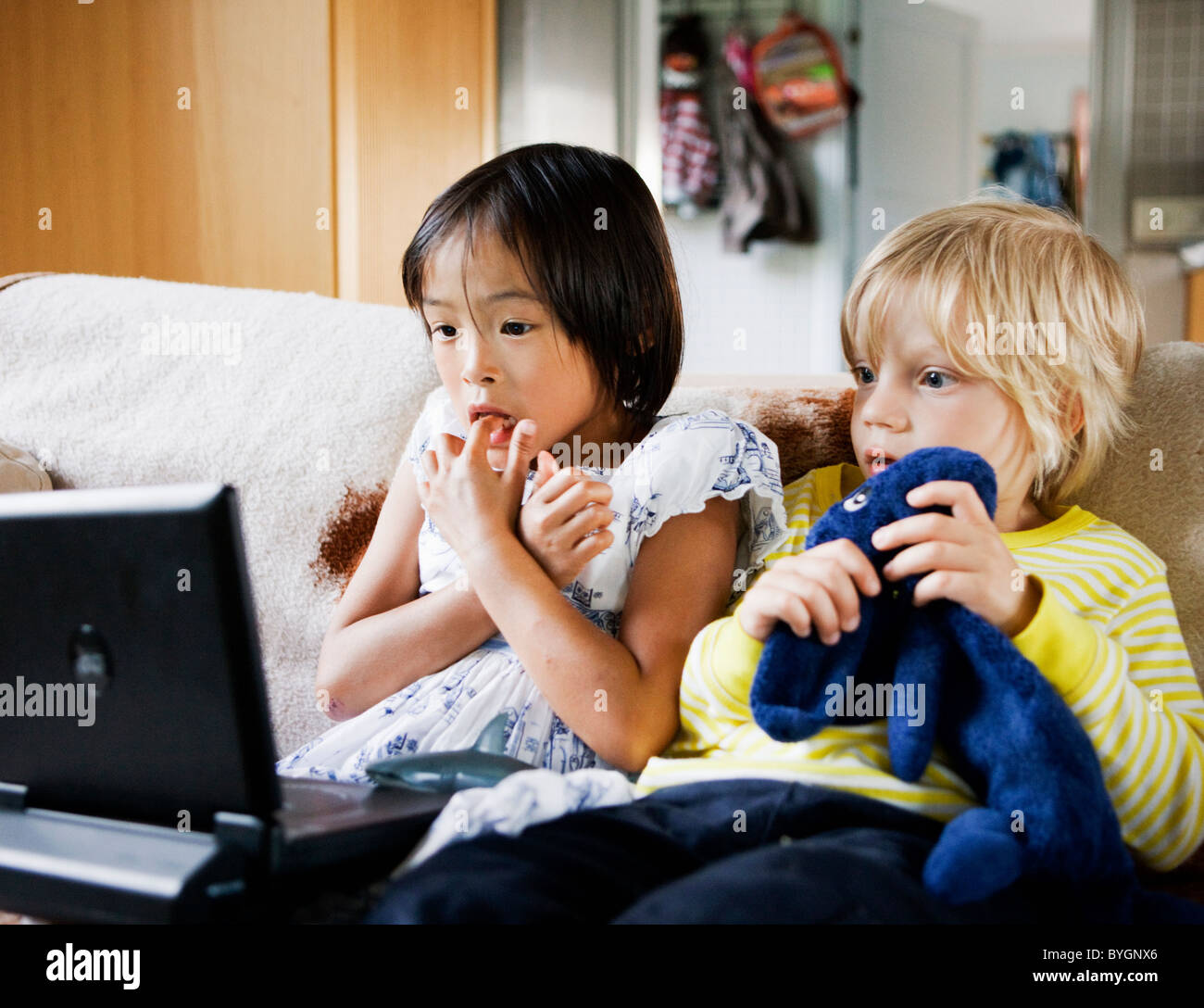 Boy and girl watching tv on sofa Stock Photo
