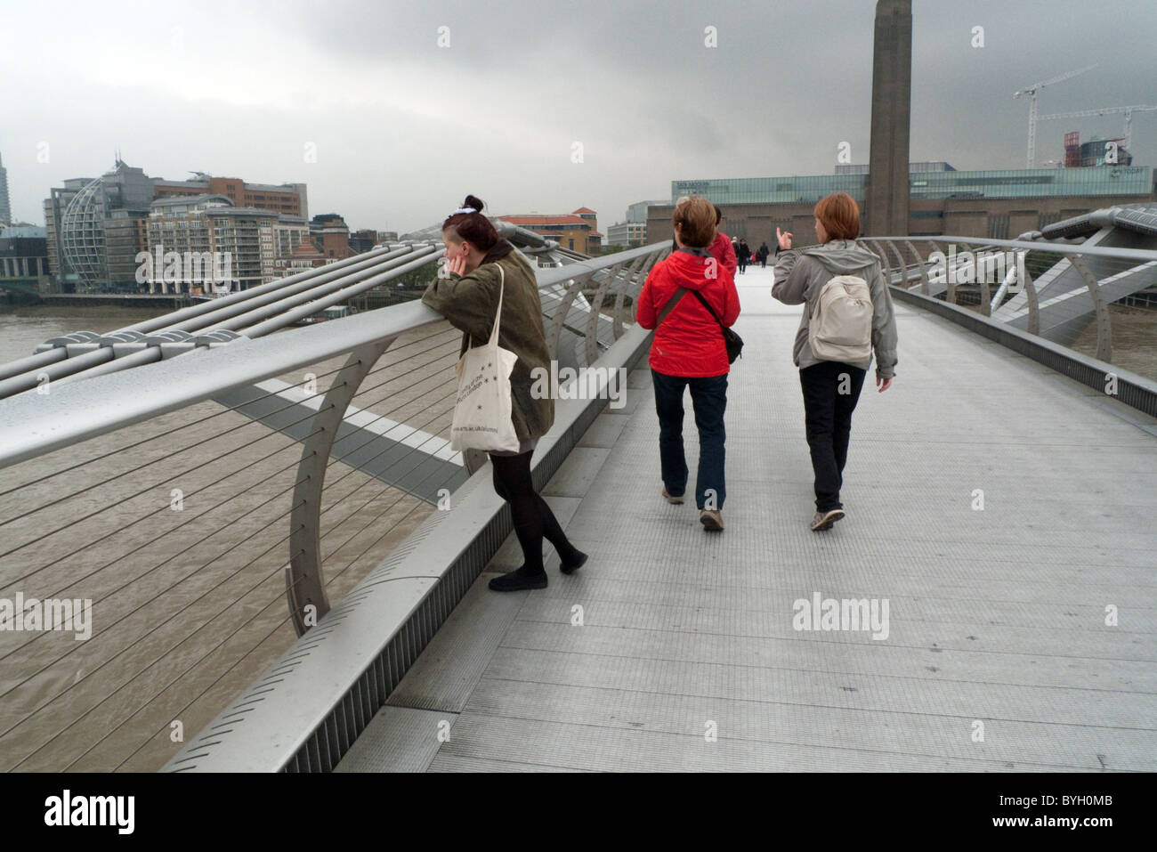 People walking over the Millennium Bridge on a winter day in London England KATHY DEWITT Stock Photo