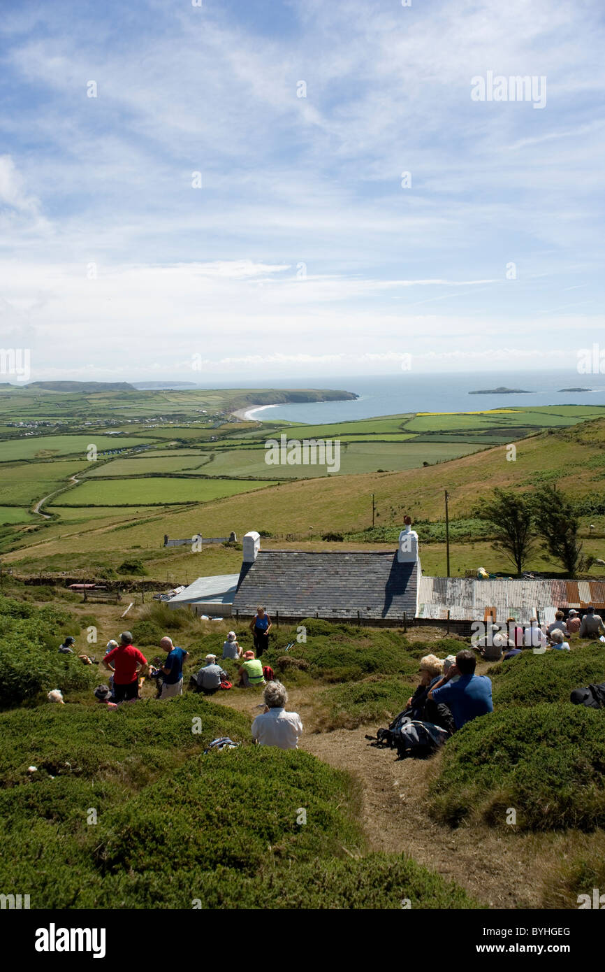 Ramblers resting overlooking Aberdaron and the tip of the Lleyn Peninsula from Anelog hill Stock Photo