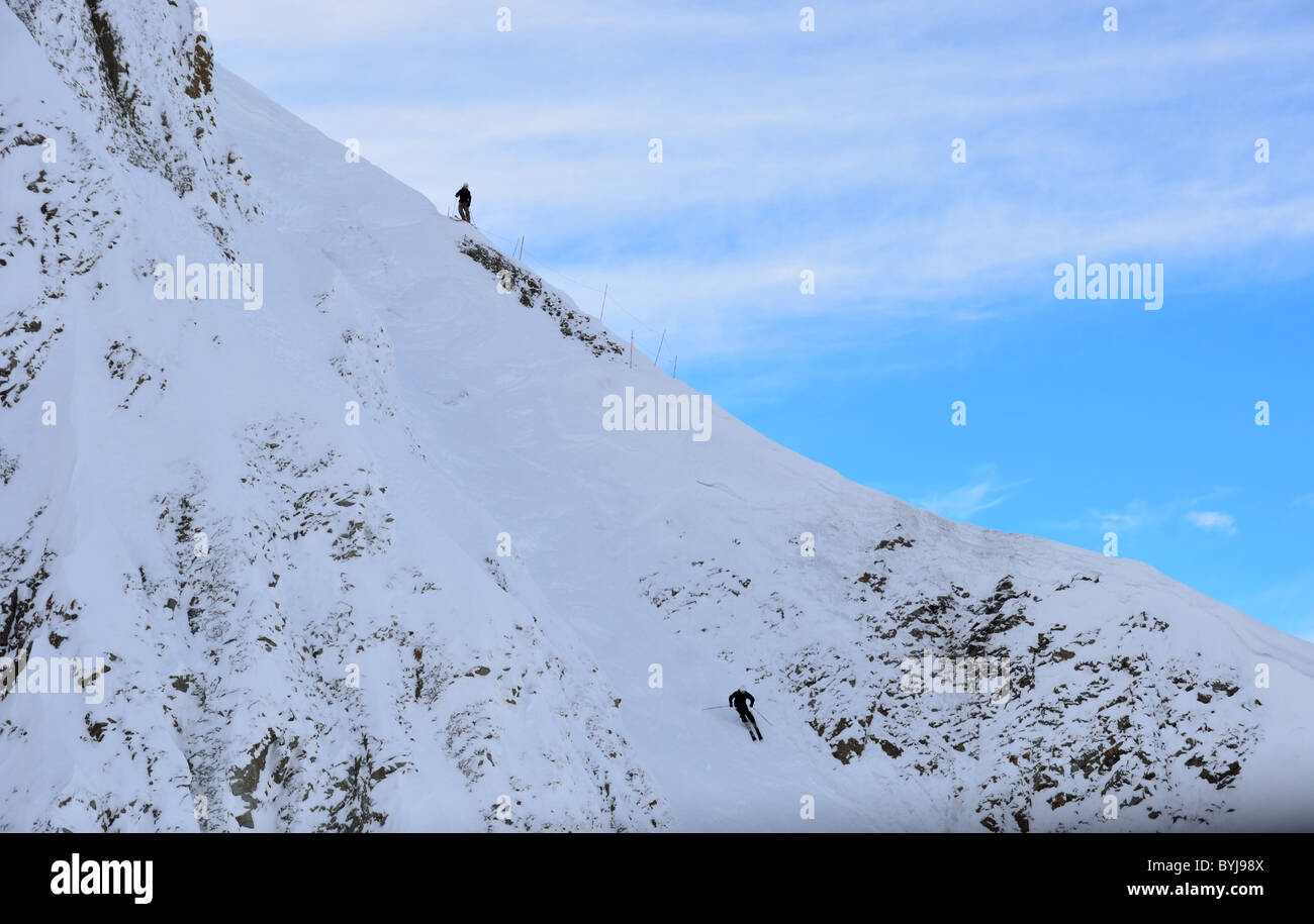 Two skiers shooting down a rocky slope. Big Sky Ski Resort, Montana, USA. Stock Photo