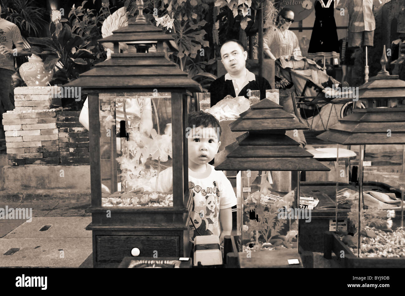 Sepia-toned photograph of a young Thai boy at a street market in Chiang Mai Stock Photo