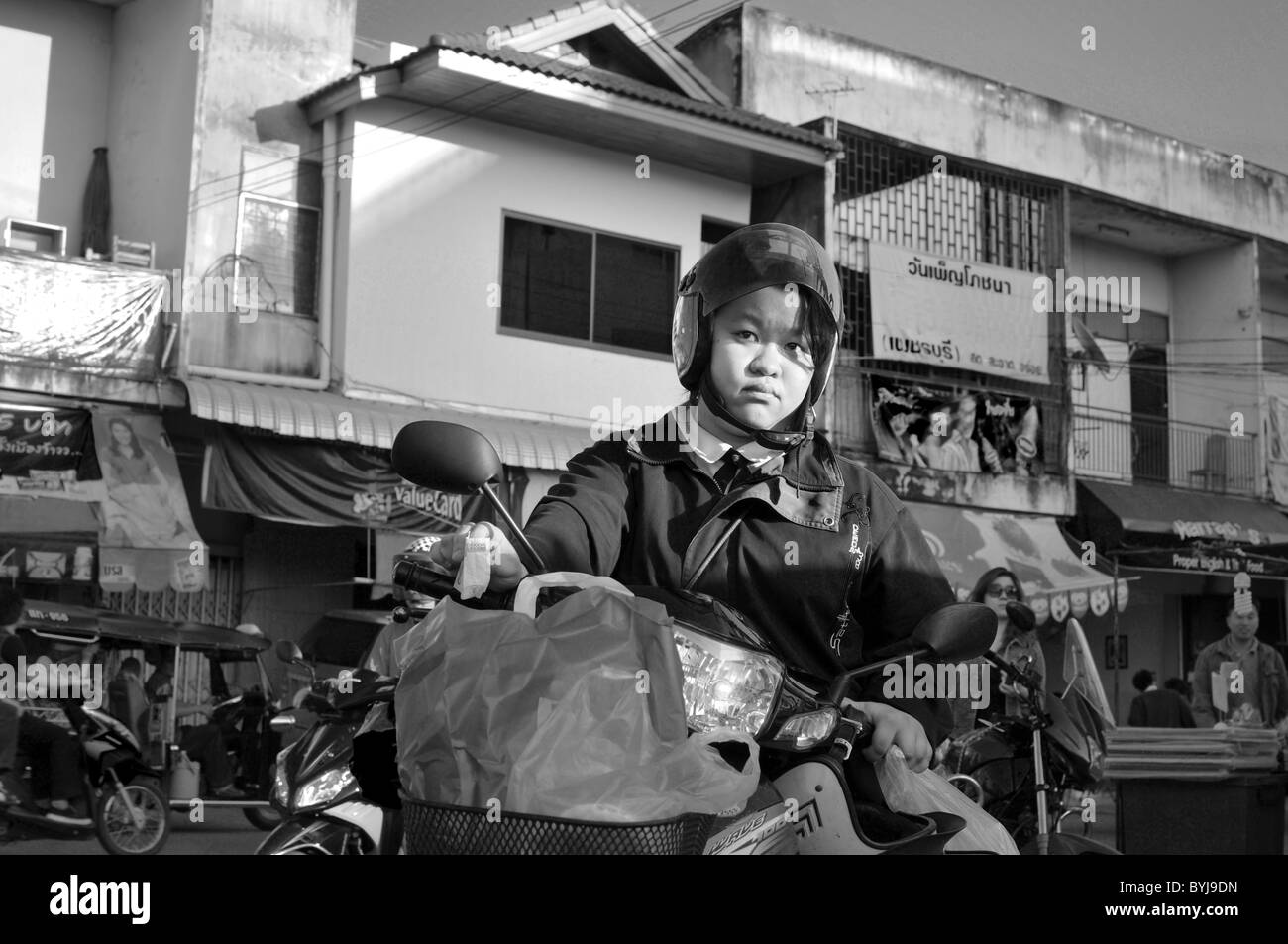Black and white photograph of a young Thai woman on a motorbike Stock Photo
