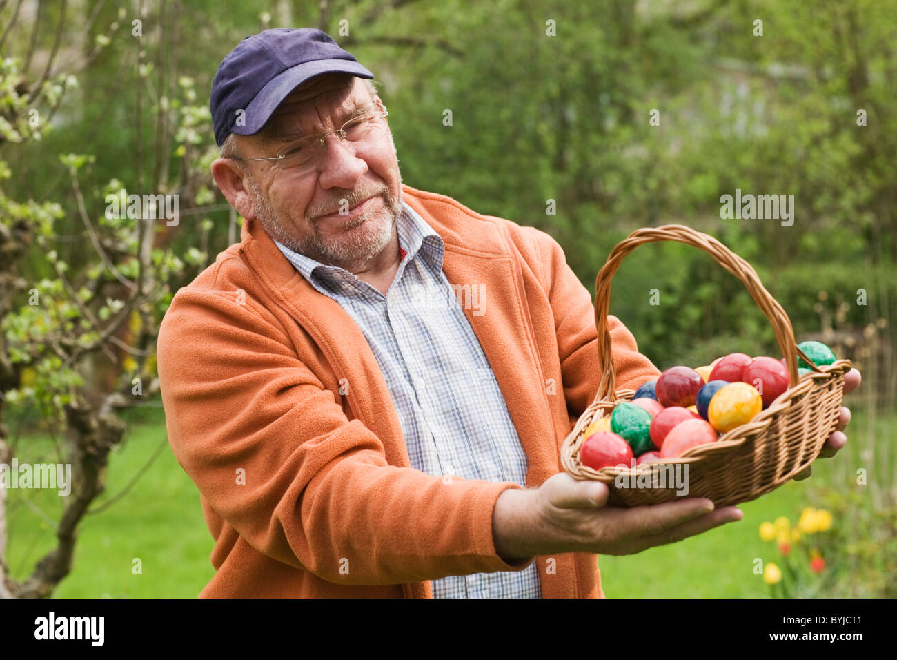Elderly man holding basket of Easter eggs Stock Photo Alamy