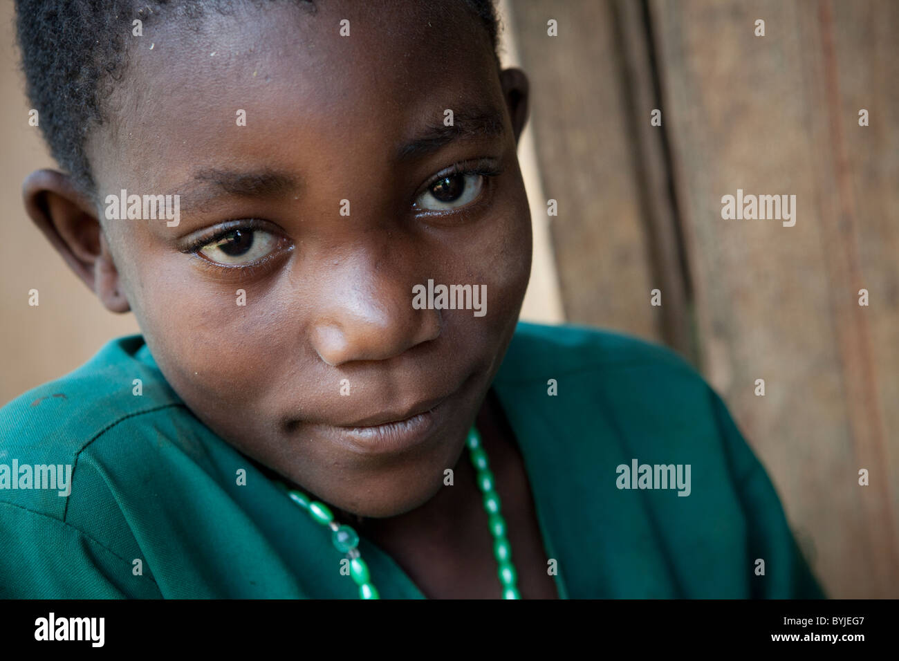 A young child sits outside her house in rural Masaka, Uganda, East Africa. Stock Photo