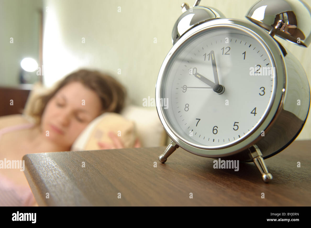 Young girl and alarm clock. Bedtime scene Stock Photo Alamy