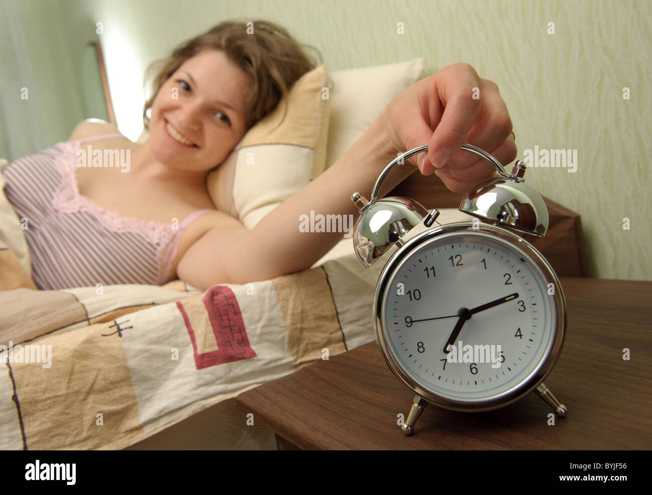 Young girl and alarm clock. Bedtime scene Stock Photo Alamy