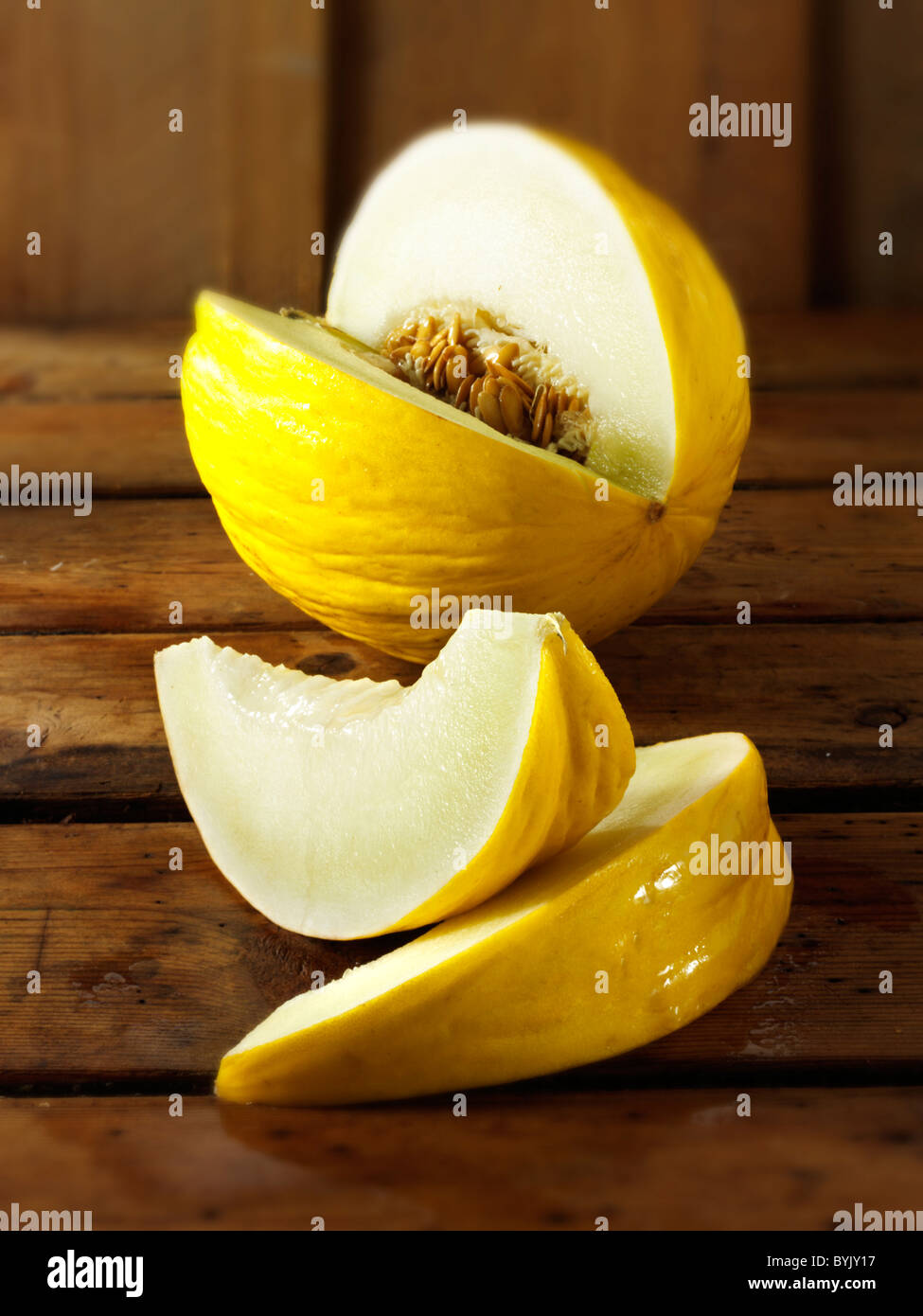 Fresh cut honeydew melons on a table setting in a kitchen Stock Photo