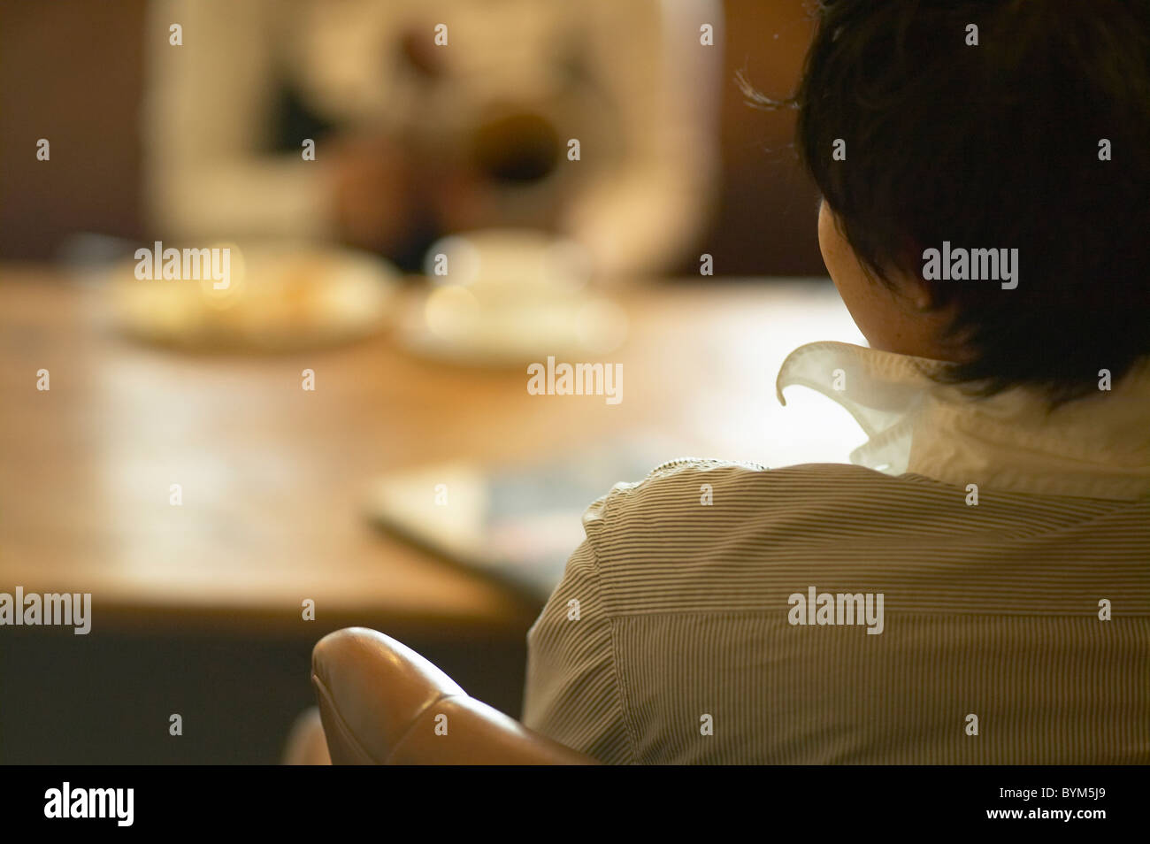 Rear view seated woman chair hi-res stock photography and images - Alamy