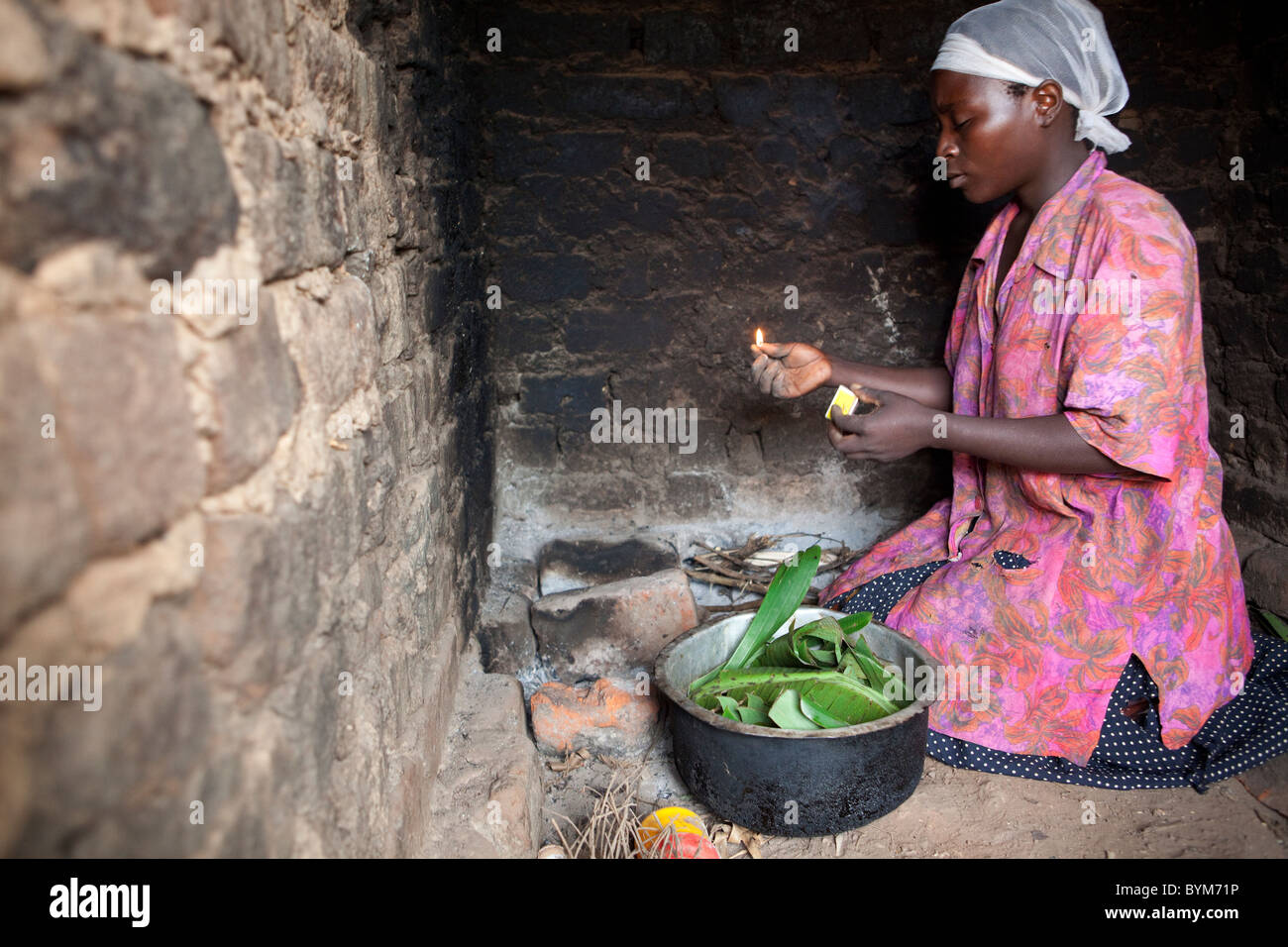 A woman prepares a meal of bananas for her family in rural Masaka, Uganda, East Africa. Stock Photo