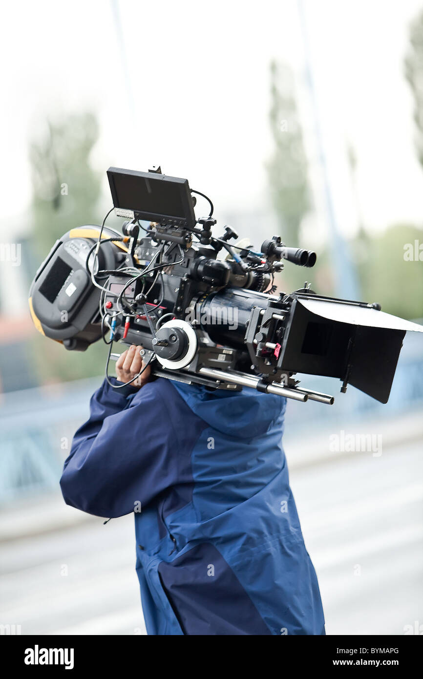 Camera operator carrying equipment Stock Photo - Alamy