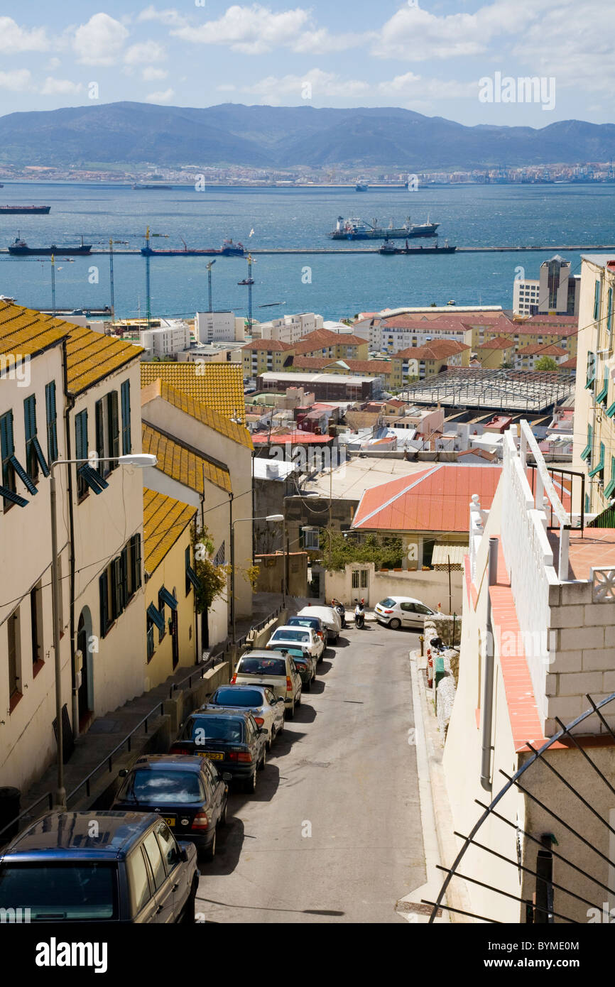Typical traditional Gibraltar street / streets / road, with houses & parked cars, looking over sea towards Spain & Spanish land. Stock Photo
