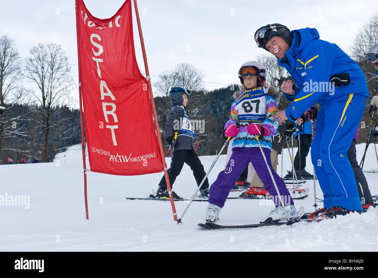 Girl with instructor at the start of a slalom race for beginners in Niederau in Austria Stock Photo