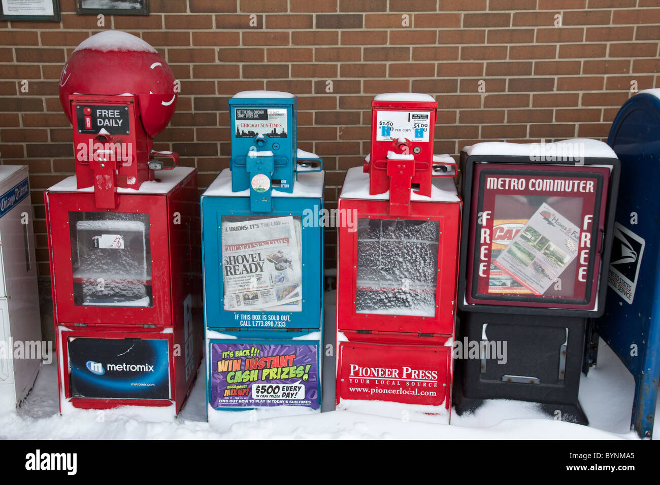 Newspaper vending machines after the Chicago Blizzard of 2011. Oak Park, Illinois. One headline refers to blizzard. Stock Photo