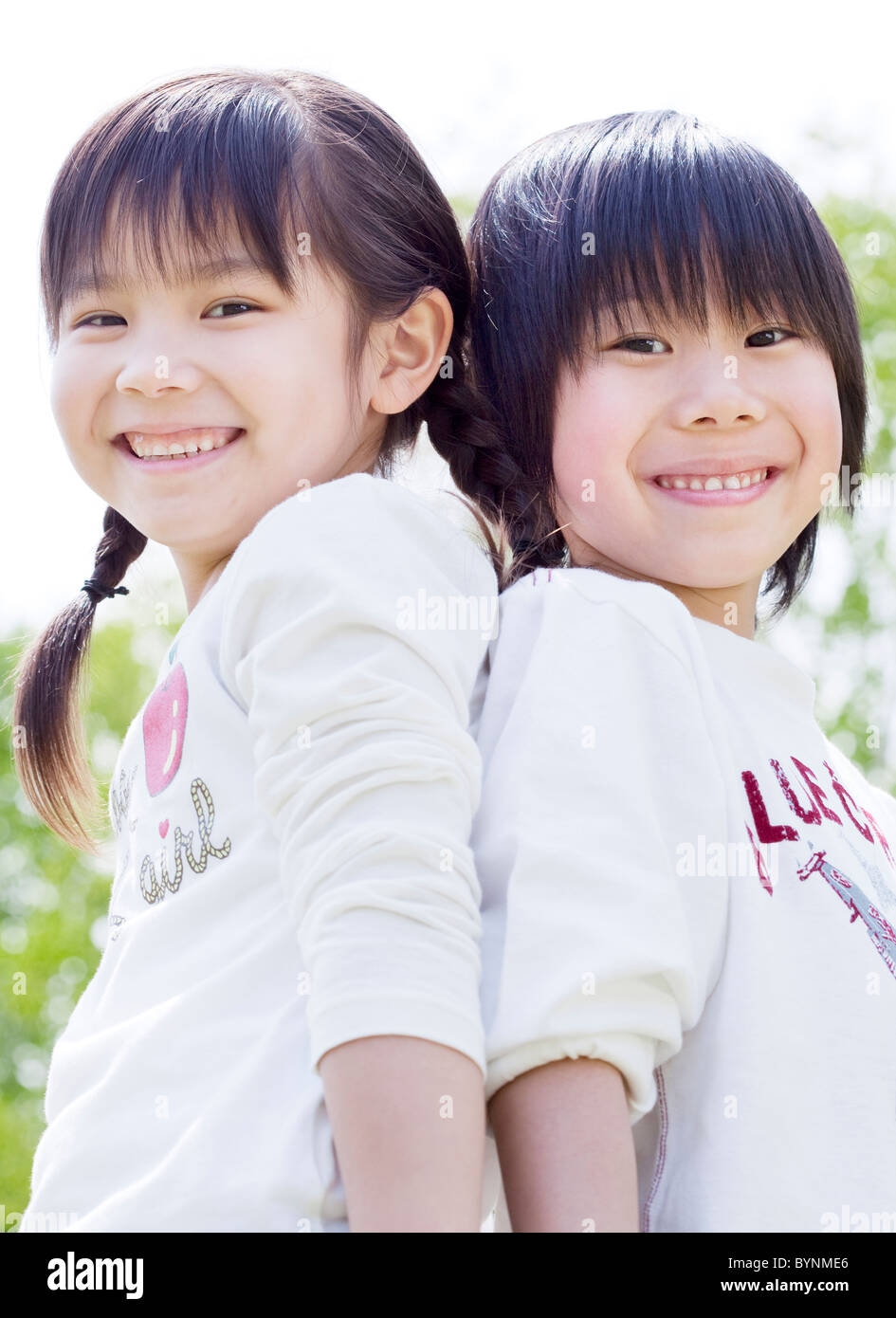 Boy Girl Standing Back To Back Looking At Camera Stock Photo - Alamy