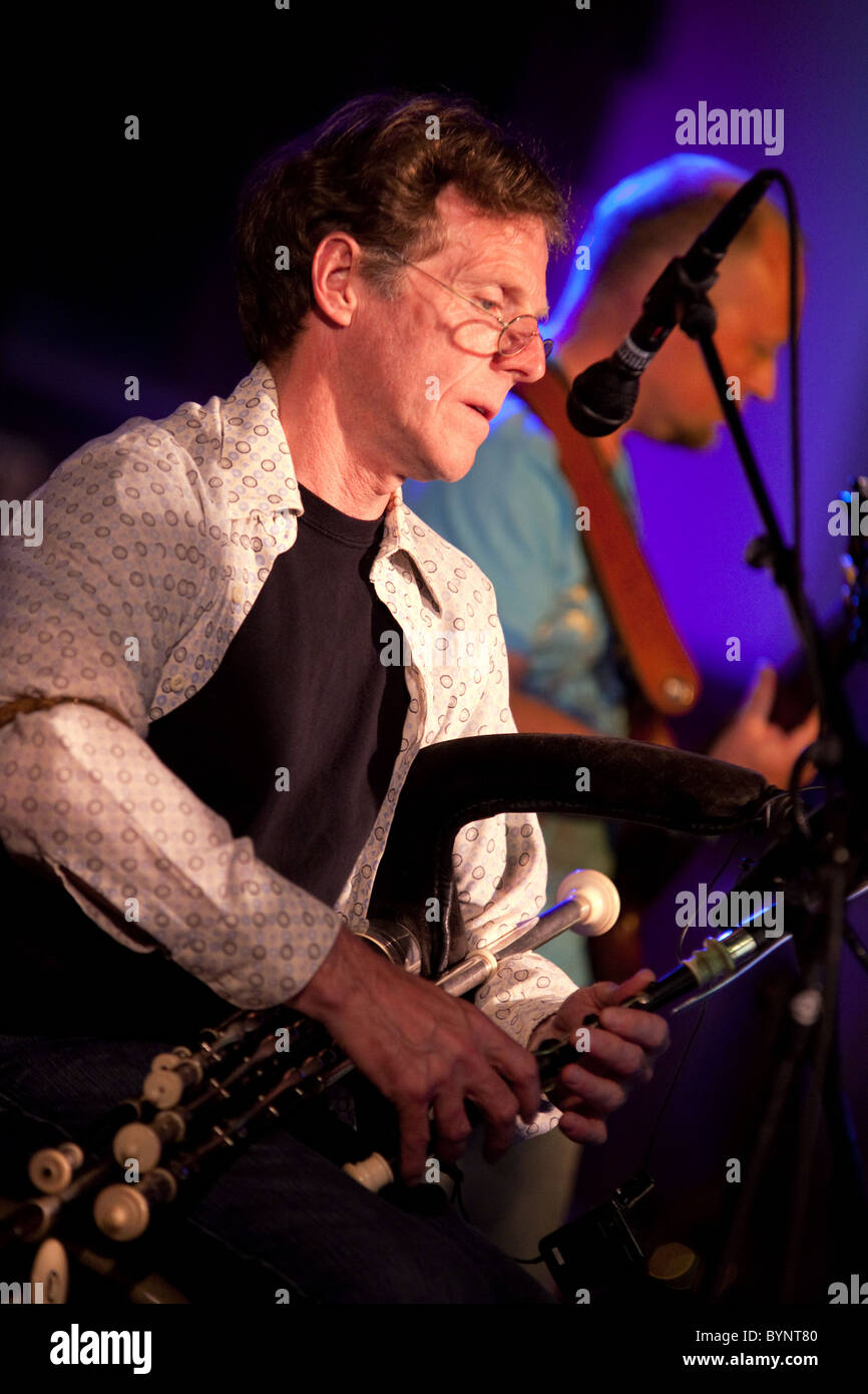 Musician Martin Nolan playing the Uillean pipes (bagpipe) on stage with the celtic rock band Iona, UK 2010 Stock Photo