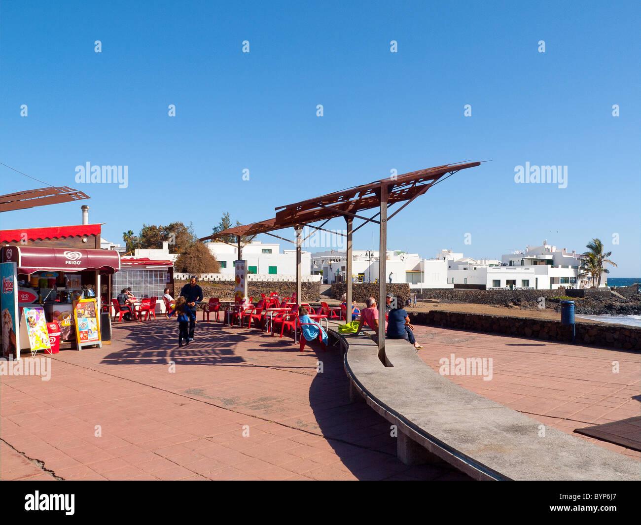 Holidaymakers in the café on the sea front at Arrieta Lanzarote Stock Photo