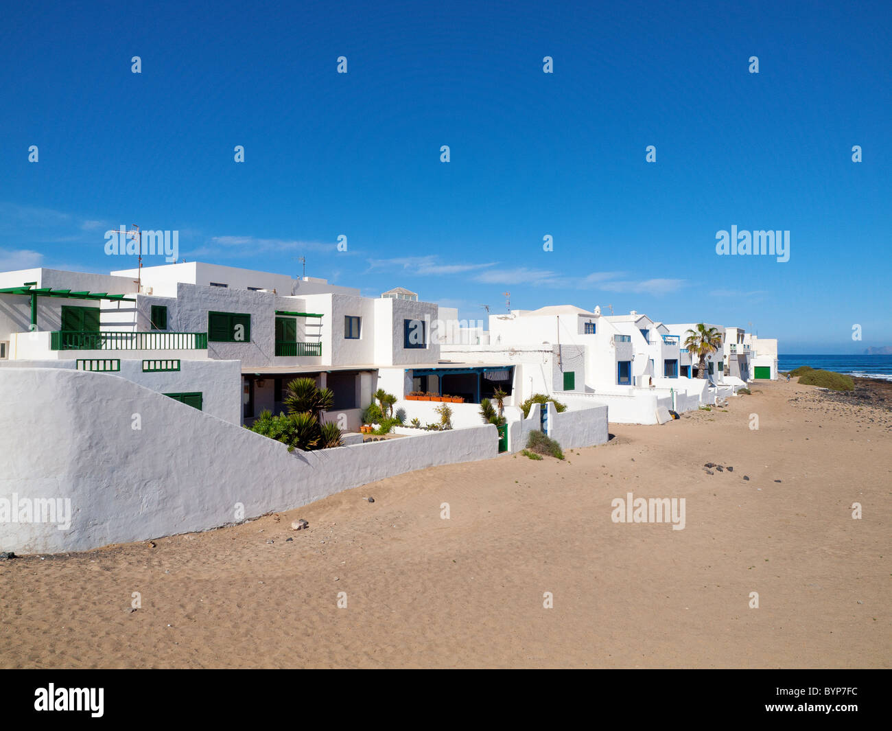 Holiday villas facing the Playa de Famara beach on the undeveloped North West coast of Lanzarote Canary Islands Stock Photo