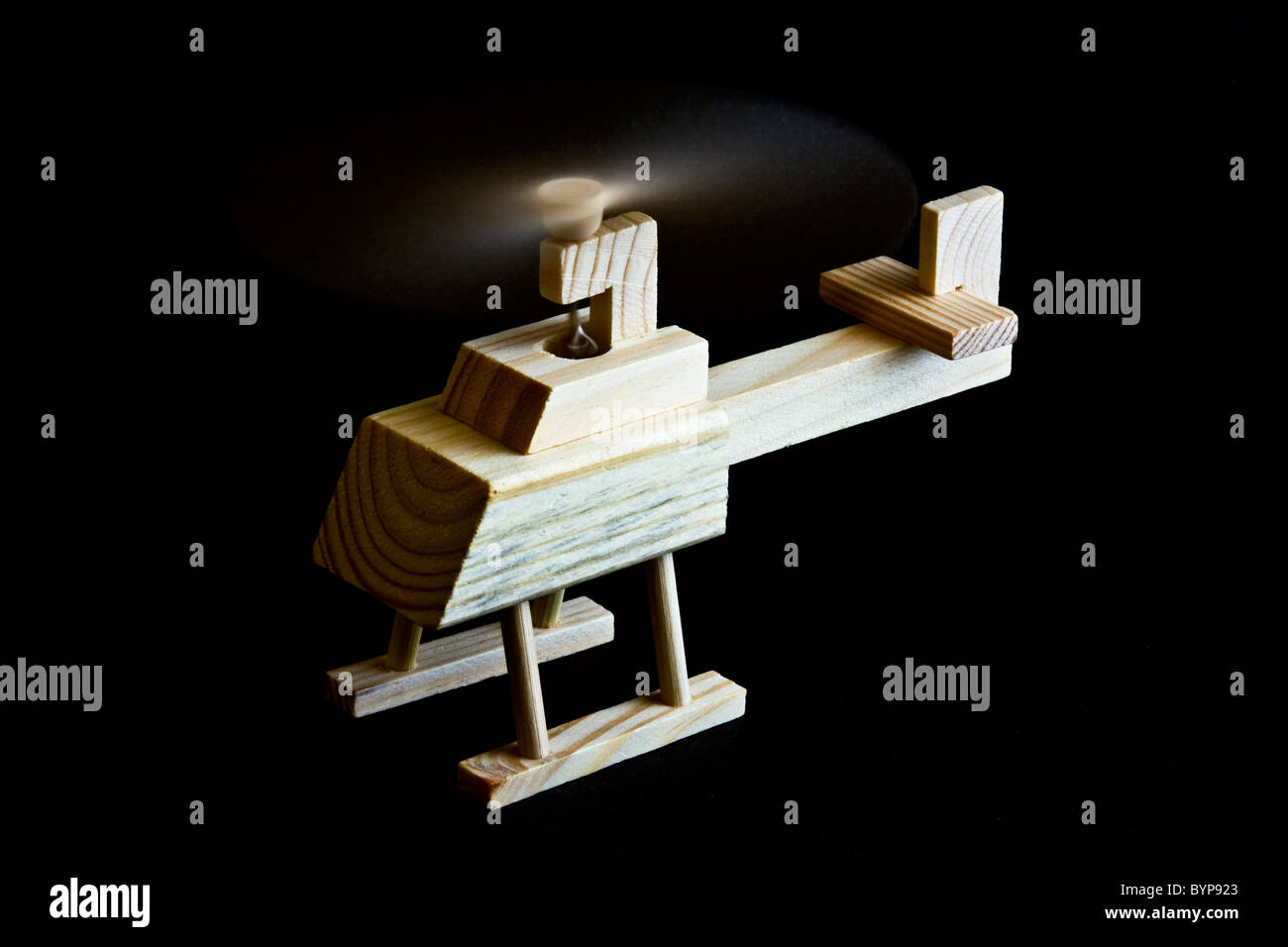 Wooden toy helicopter with spinning blade on Black background Stock Photo