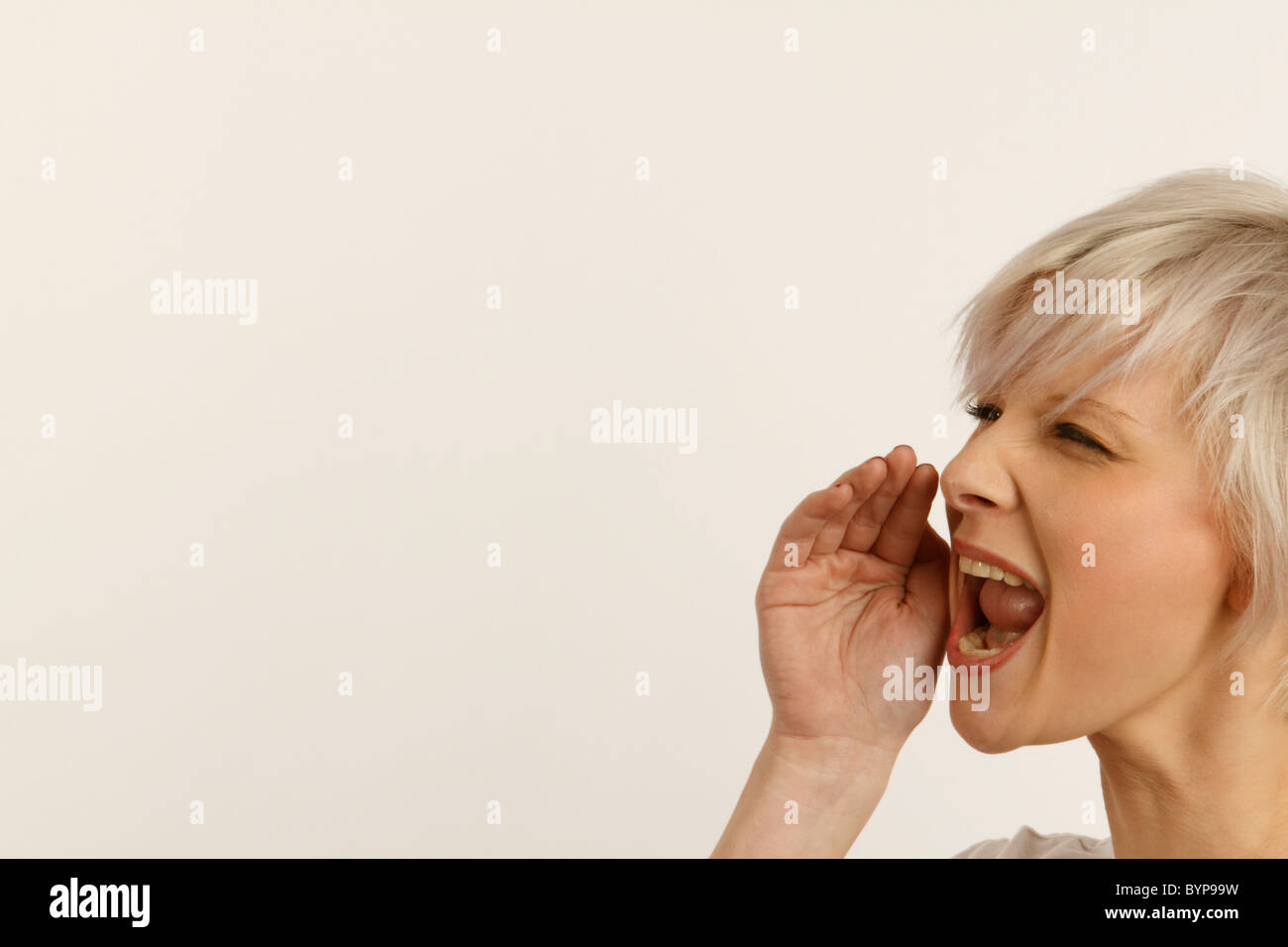 young woman shouting with her cupped hand to help with projection Stock Photo