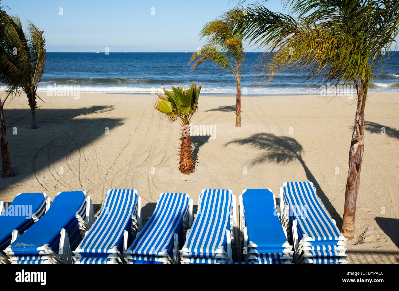 USA, New Jersey, Monmouth Beach, Stacked beach chairs on windswept and nearly empty beach on early summer afternoon Stock Photo