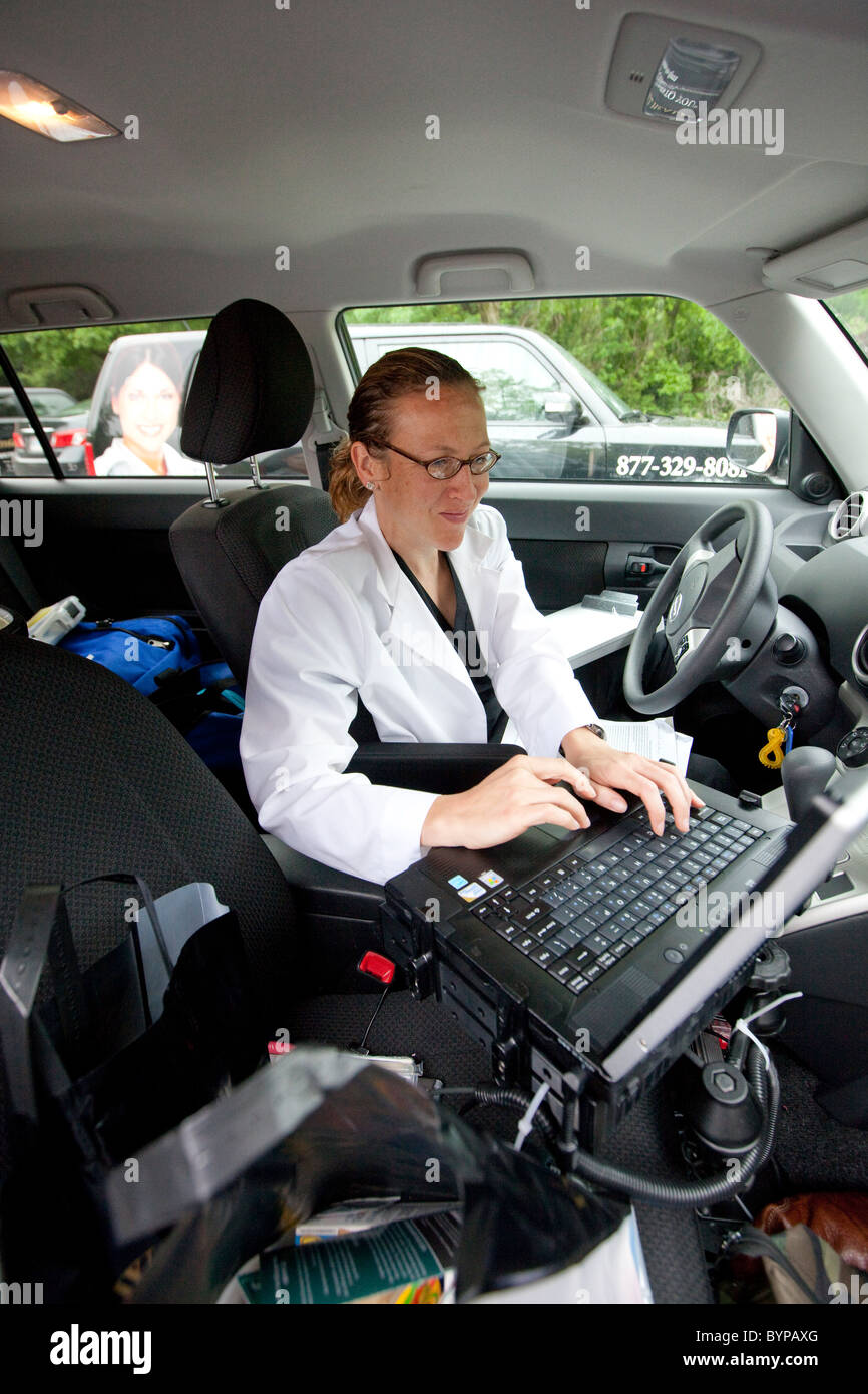 Home health care nurse logs in patient data on a car-mounted laptop computer for a home health care service based in Austin, TX Stock Photo