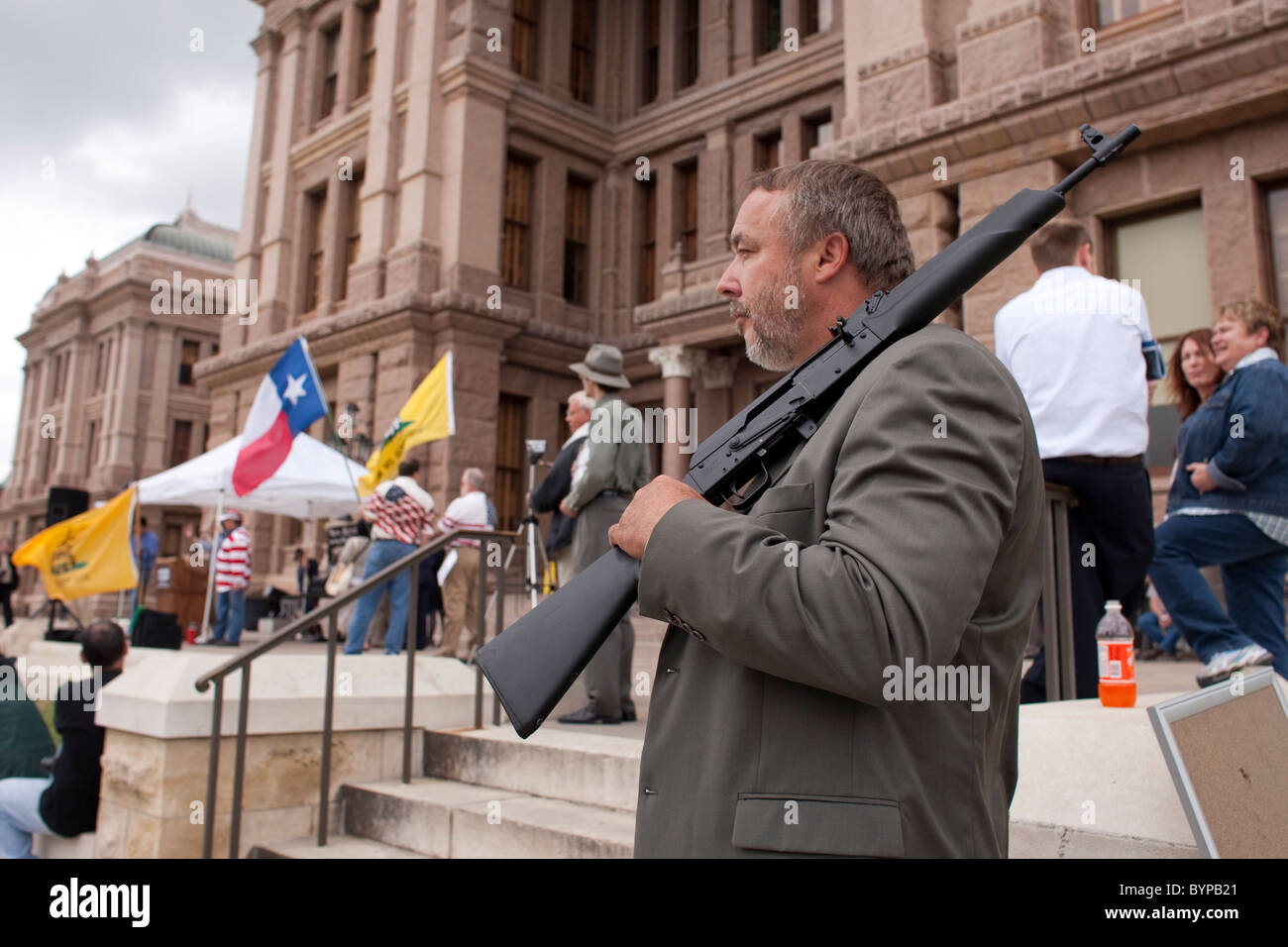 Anglo male stands in front of the Texas Capitol with an unloaded AK-47 assault rifle during a Tea Party rally in Austin Stock Photo
