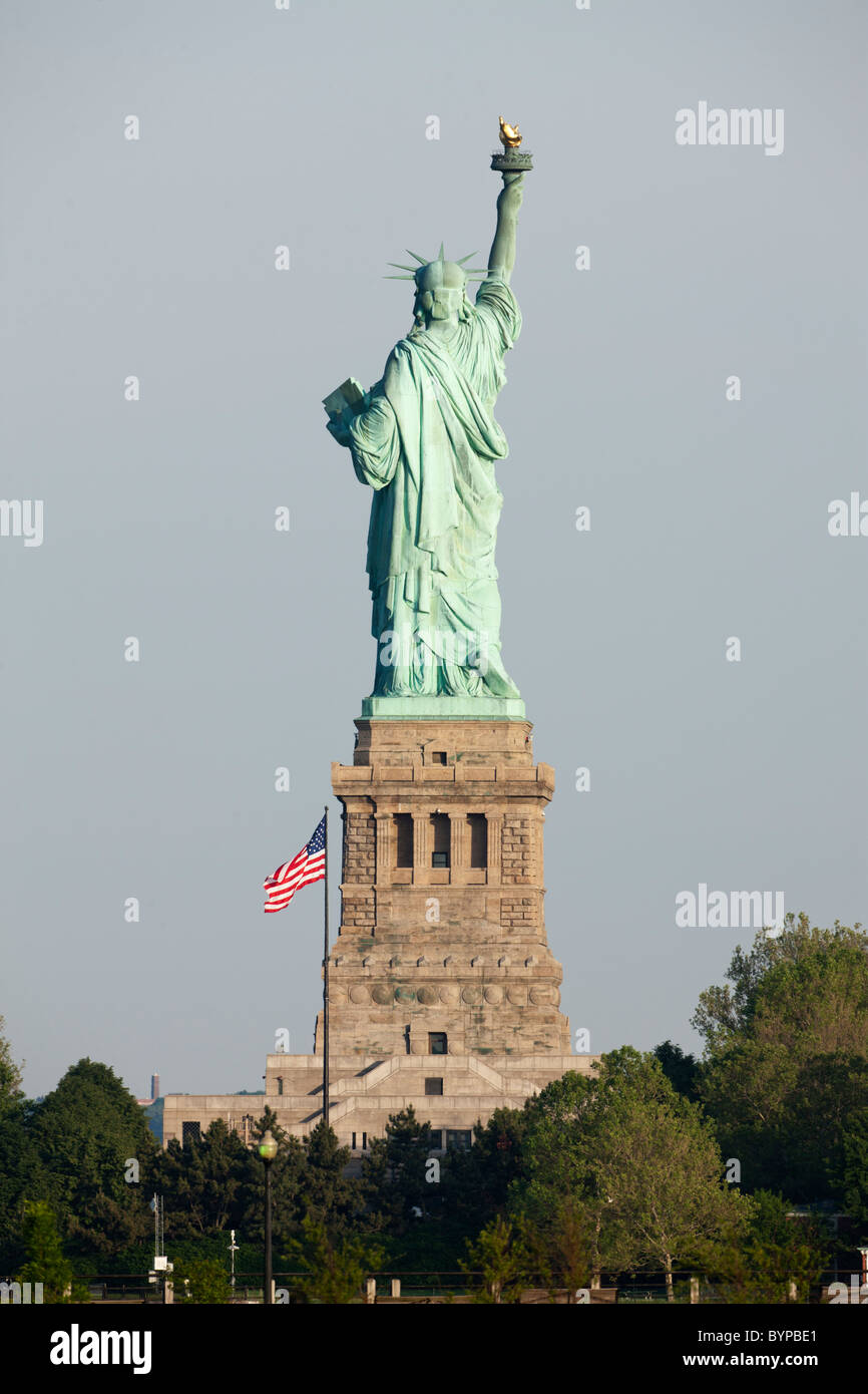 USA, New York, New York City, Rear view of Statue of Liberty at sunset on summer evening Stock Photo