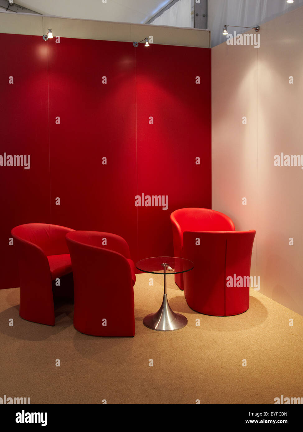 Red chairs and table situated in interior space with red and white walls, waiting area Stock Photo