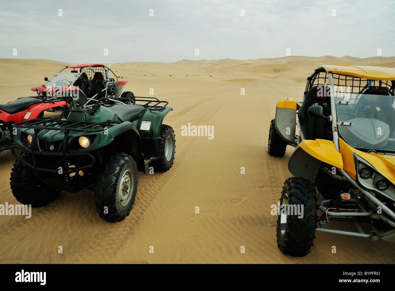 Quad bikes and 4x4 dune buggies parked on sand dunes while on extreme