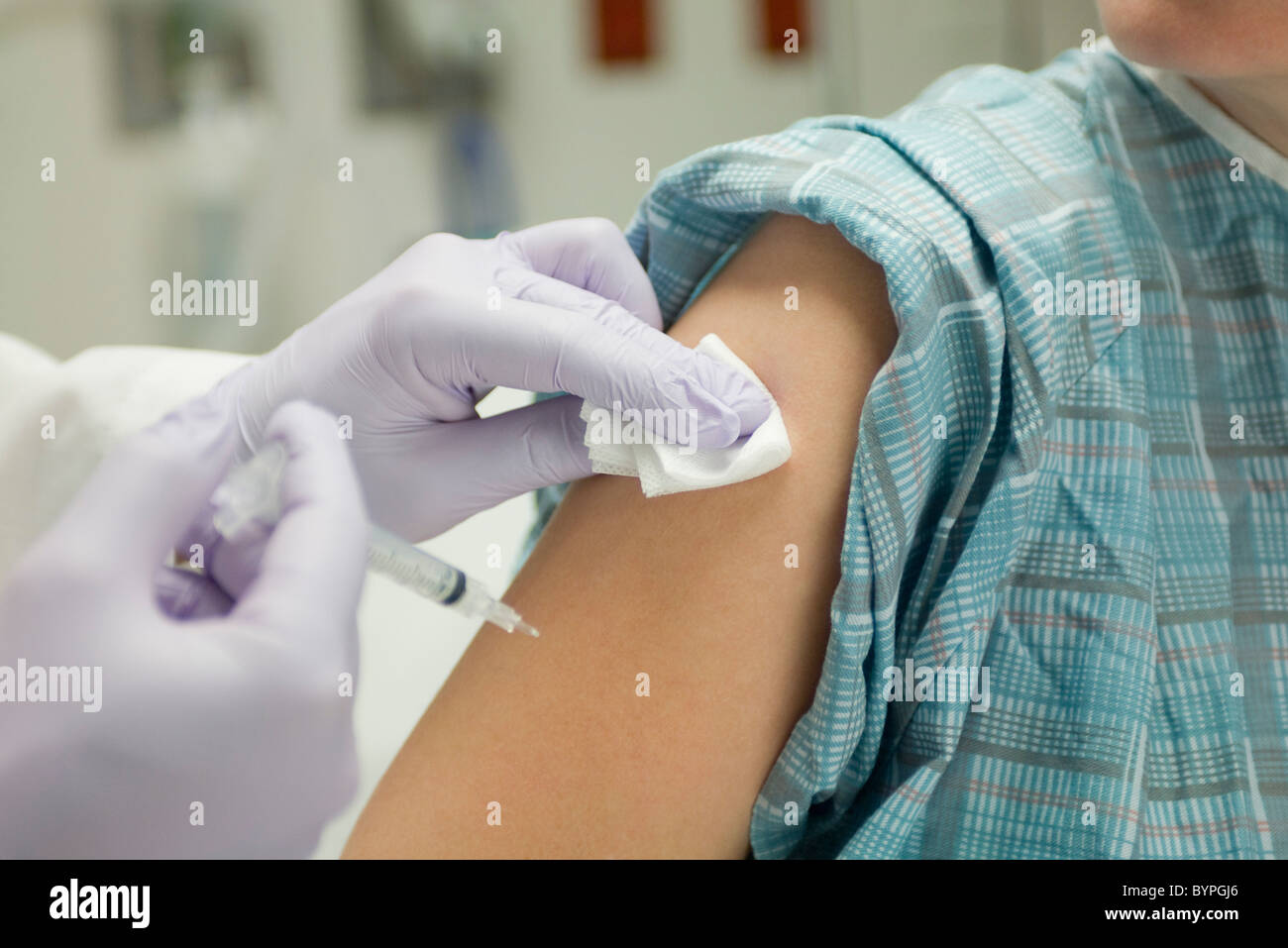 Doctor placing gauze on patient's arm after administering a shot Stock Photo