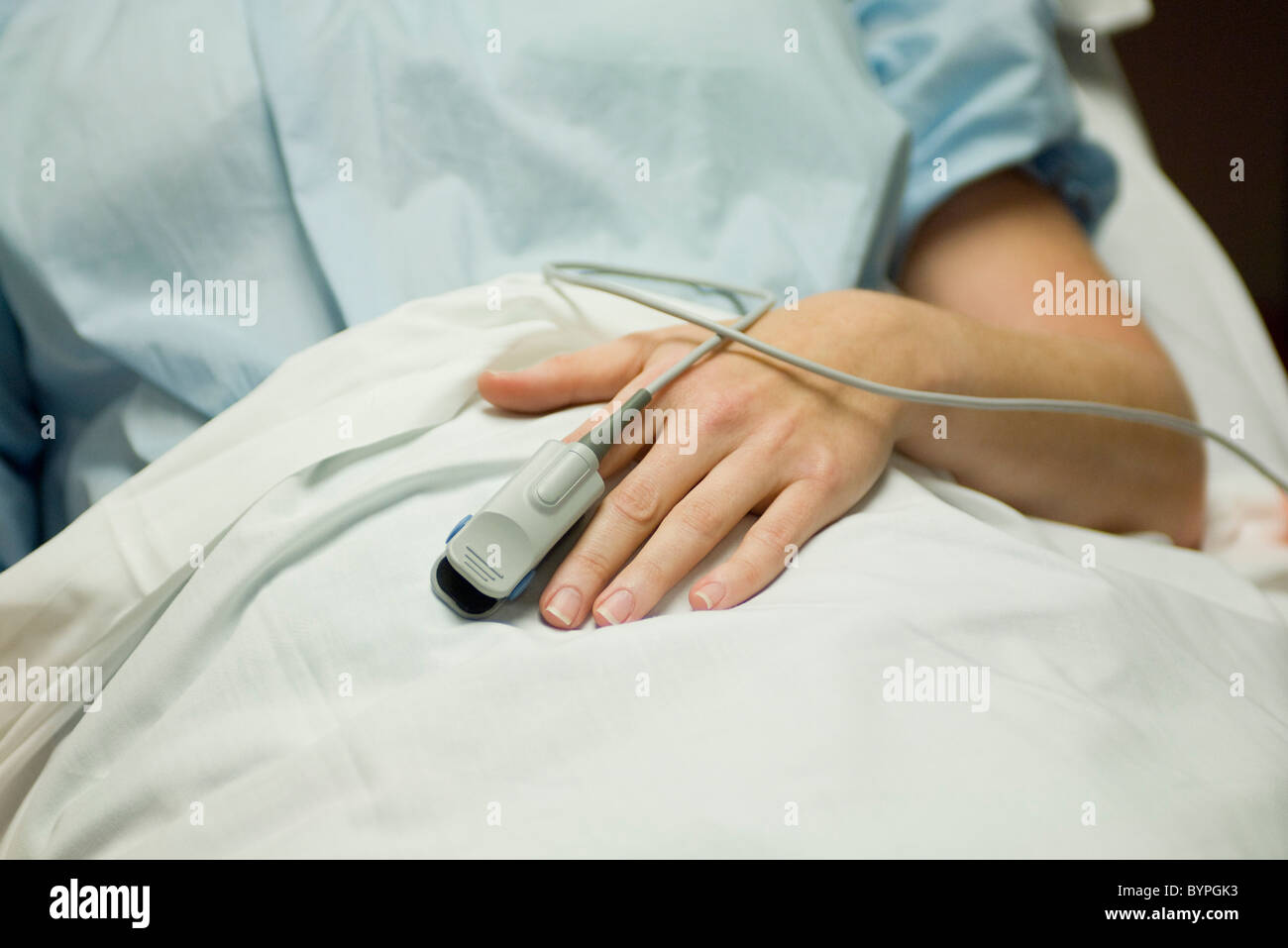 Patient wearing oximeter to monitor pulse oxygen levels Stock Photo