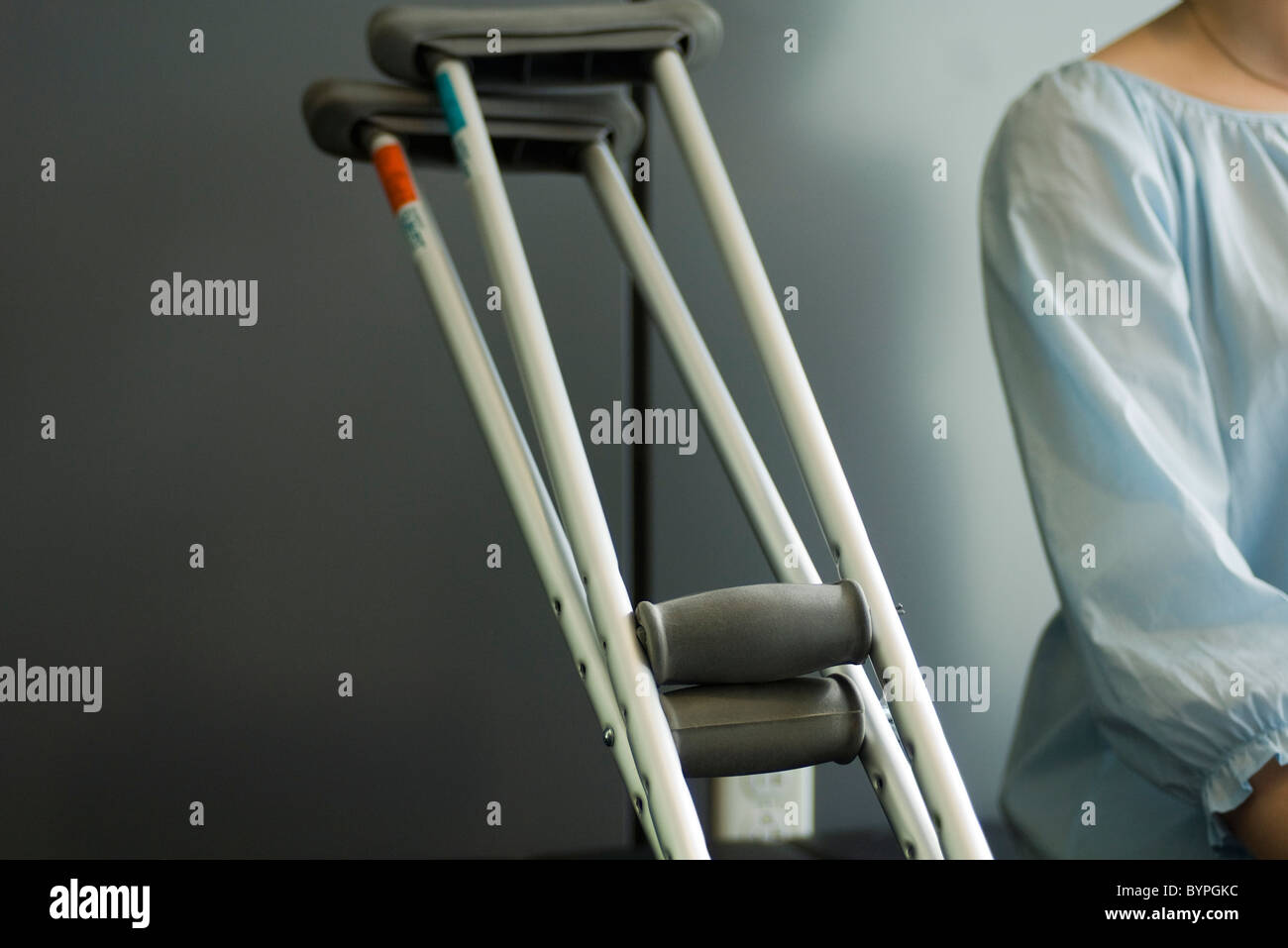 Pair of crutches resting beside seated patient Stock Photo Alamy