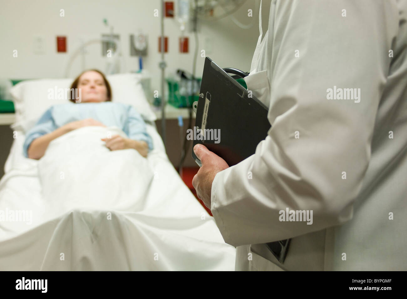 Doctor monitoring patient in hospital Stock Photo